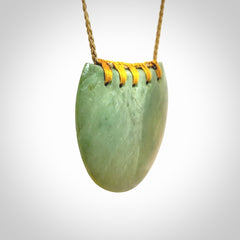 Hand carved New Zealand Flower Jade half-shield pendant.