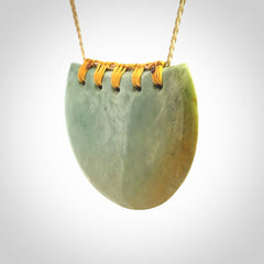Hand carved New Zealand Flower Jade half-shield pendant.