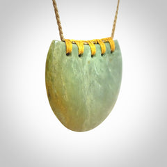 Hand carved New Zealand Flower Jade half-shield pendant.