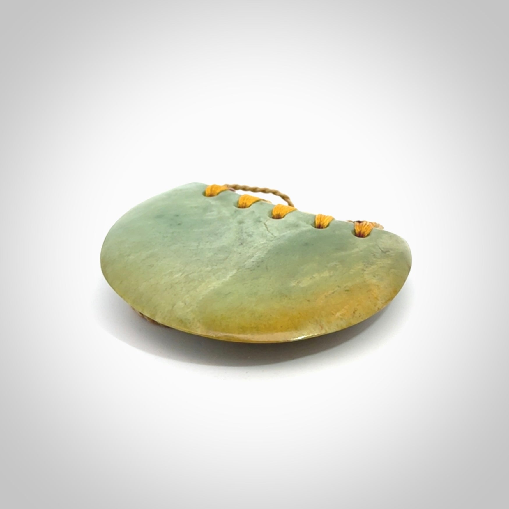 Hand carved New Zealand Flower Jade half-shield pendant.