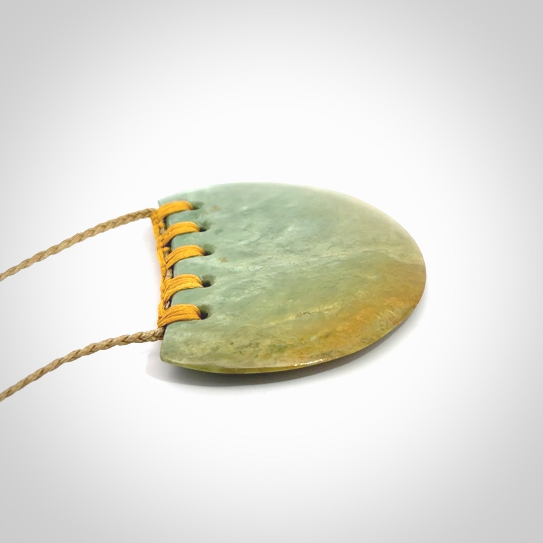 Hand carved New Zealand Flower Jade half-shield pendant.