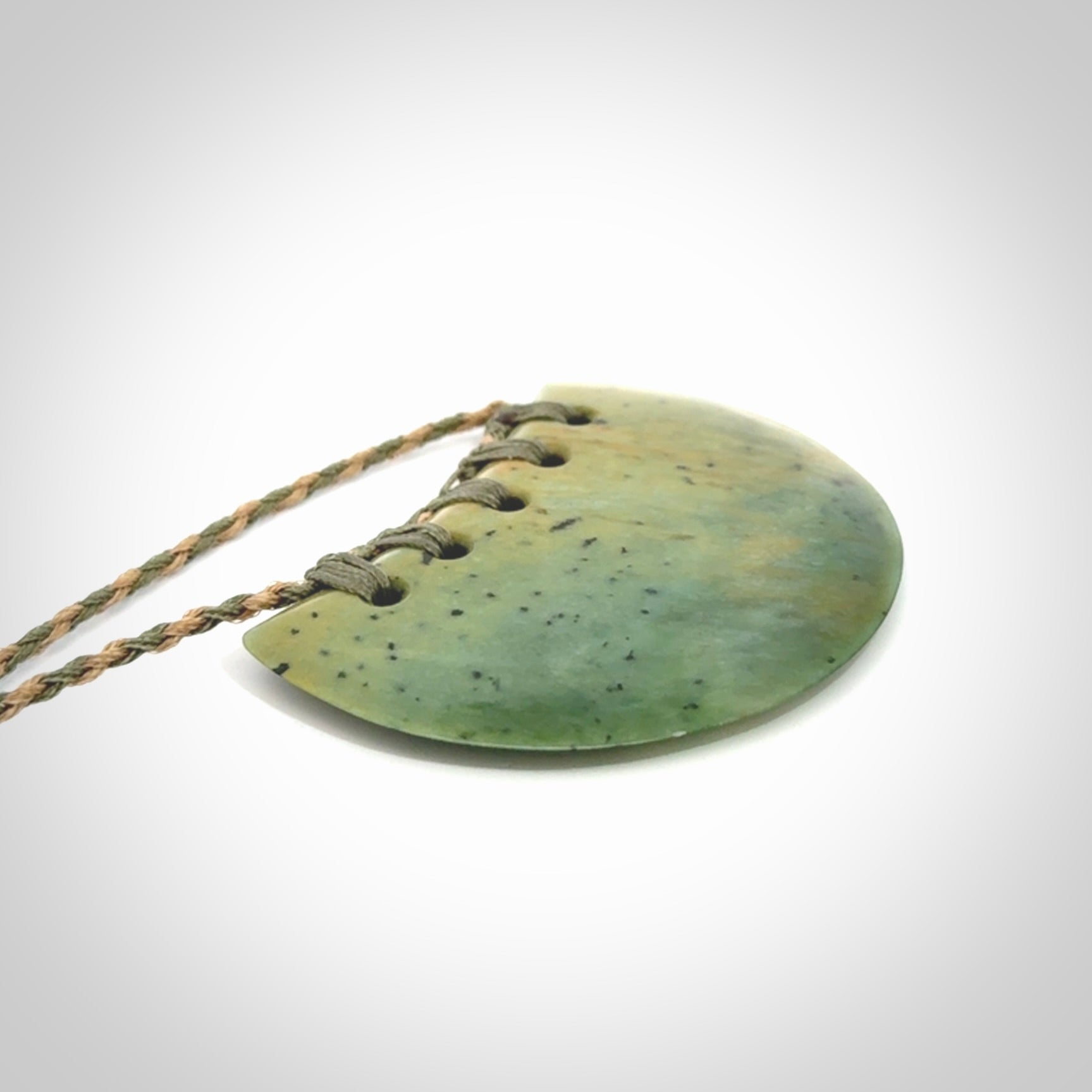 Hand carved New Zealand Flower Jade half-shield pendant.