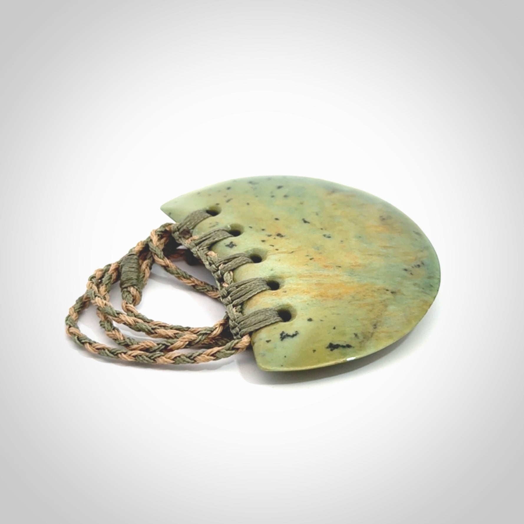 Hand carved New Zealand Flower Jade half-shield pendant.