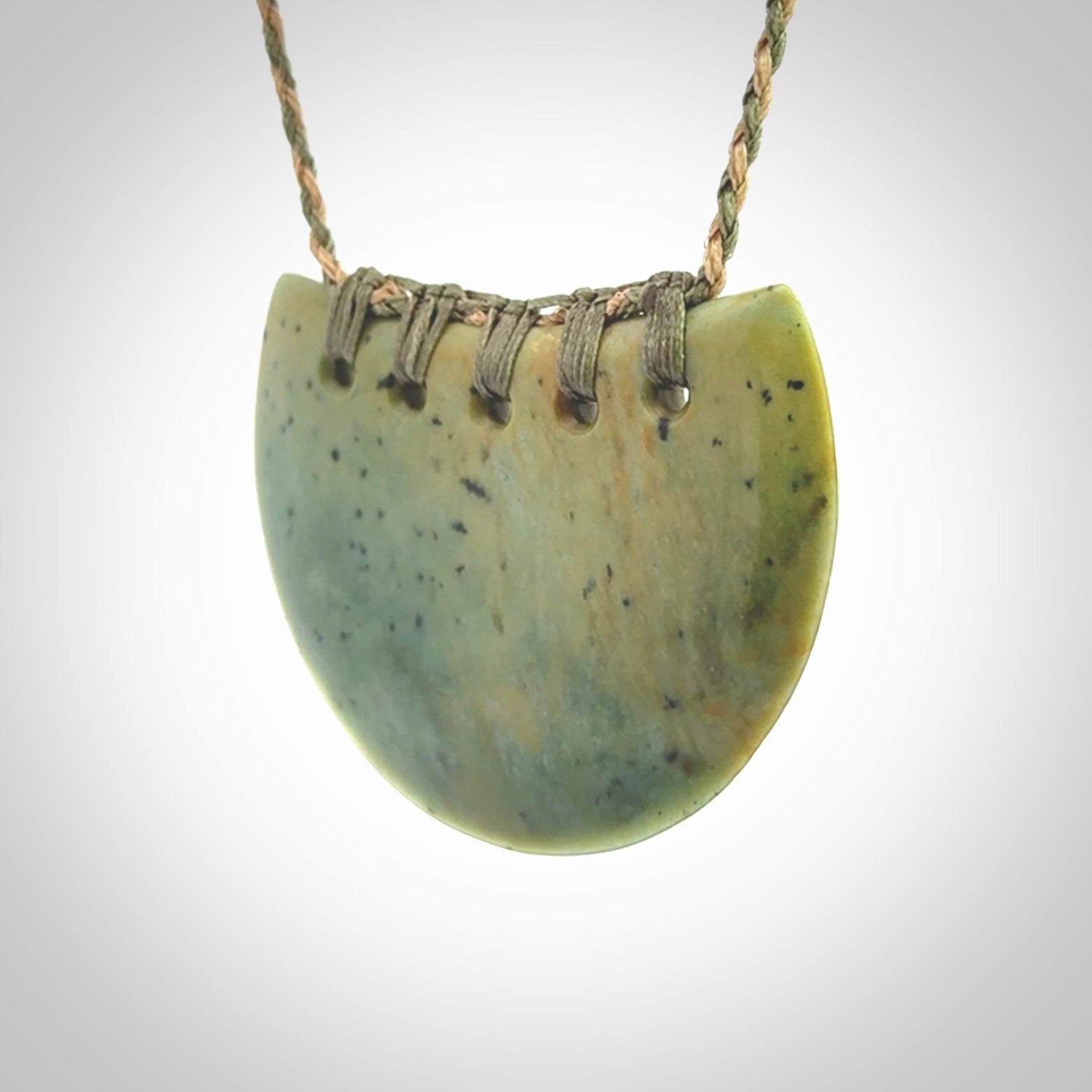 Hand carved New Zealand Flower Jade half-shield pendant.