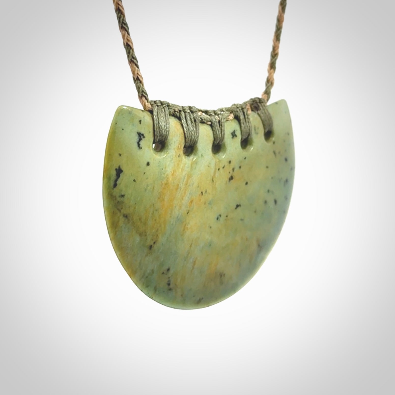 Hand carved New Zealand Flower Jade half-shield pendant.