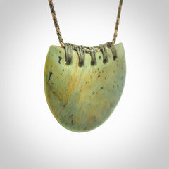 Hand carved New Zealand Flower Jade half-shield pendant.