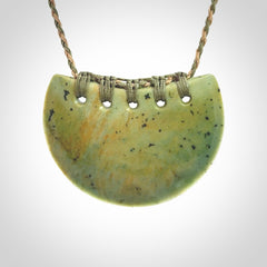 Hand carved New Zealand Flower Jade half-shield pendant.