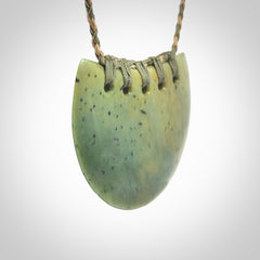 Hand carved New Zealand Flower Jade half-shield pendant.