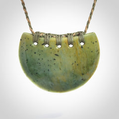 Hand carved New Zealand Flower Jade half-shield pendant.