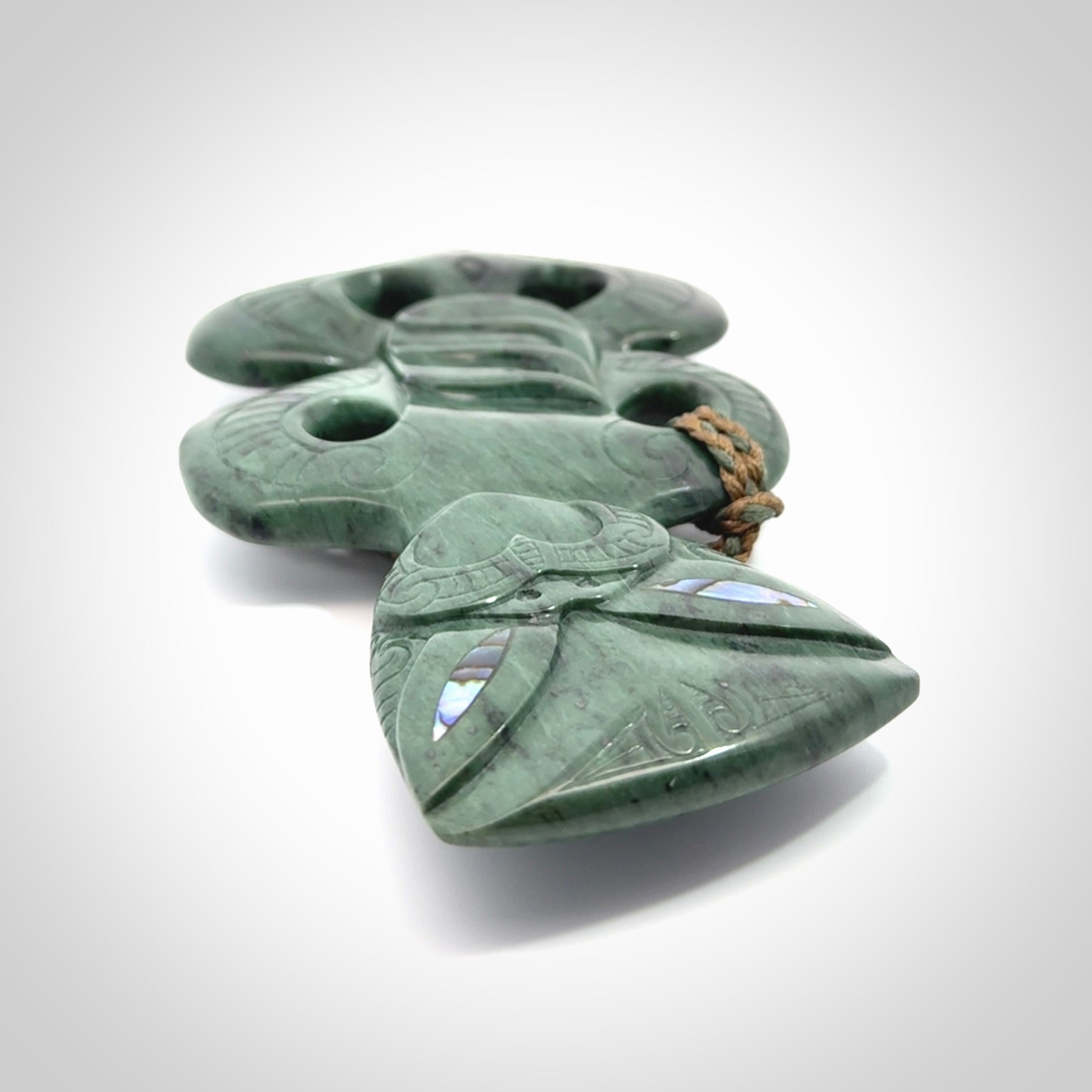 This is a large hand carved New Zealand Jade tiki pendant. It is made from New Zealand Jade and Paua shell.