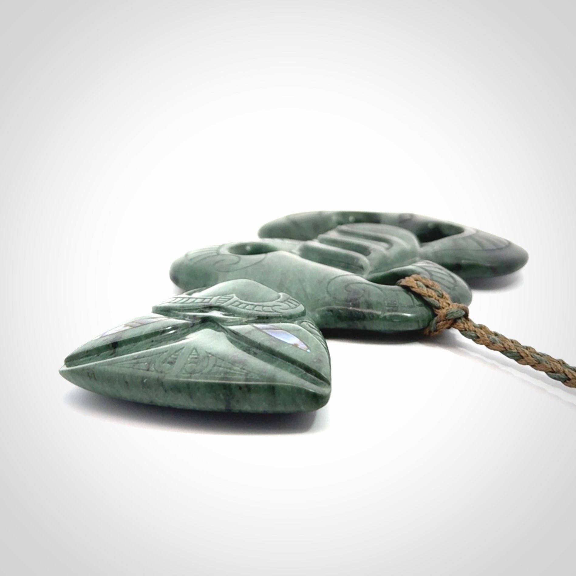 This is a large hand carved New Zealand Jade tiki pendant. It is made from New Zealand Jade and Paua shell.