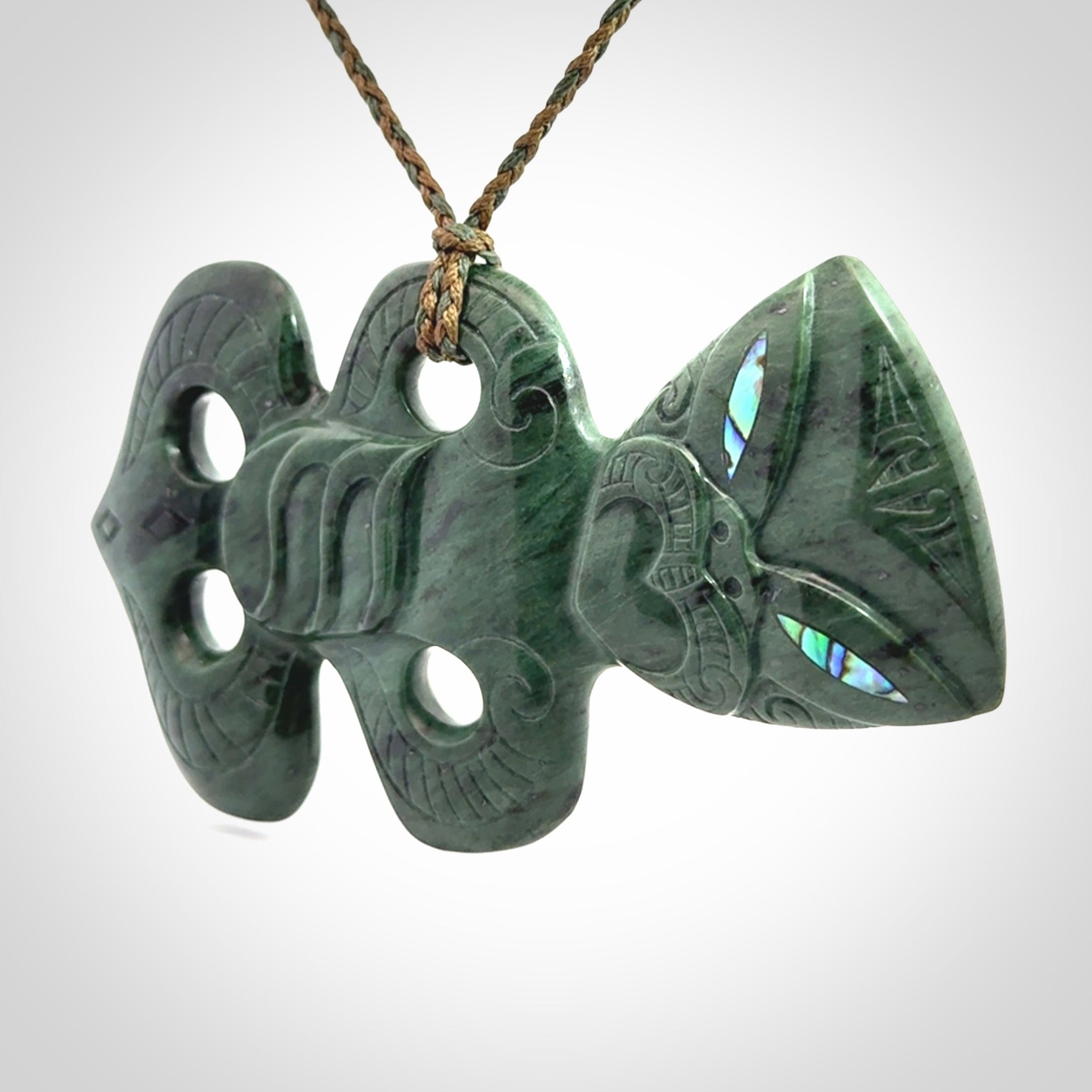 This is a large hand carved New Zealand Jade tiki pendant. It is made from New Zealand Jade and Paua shell.