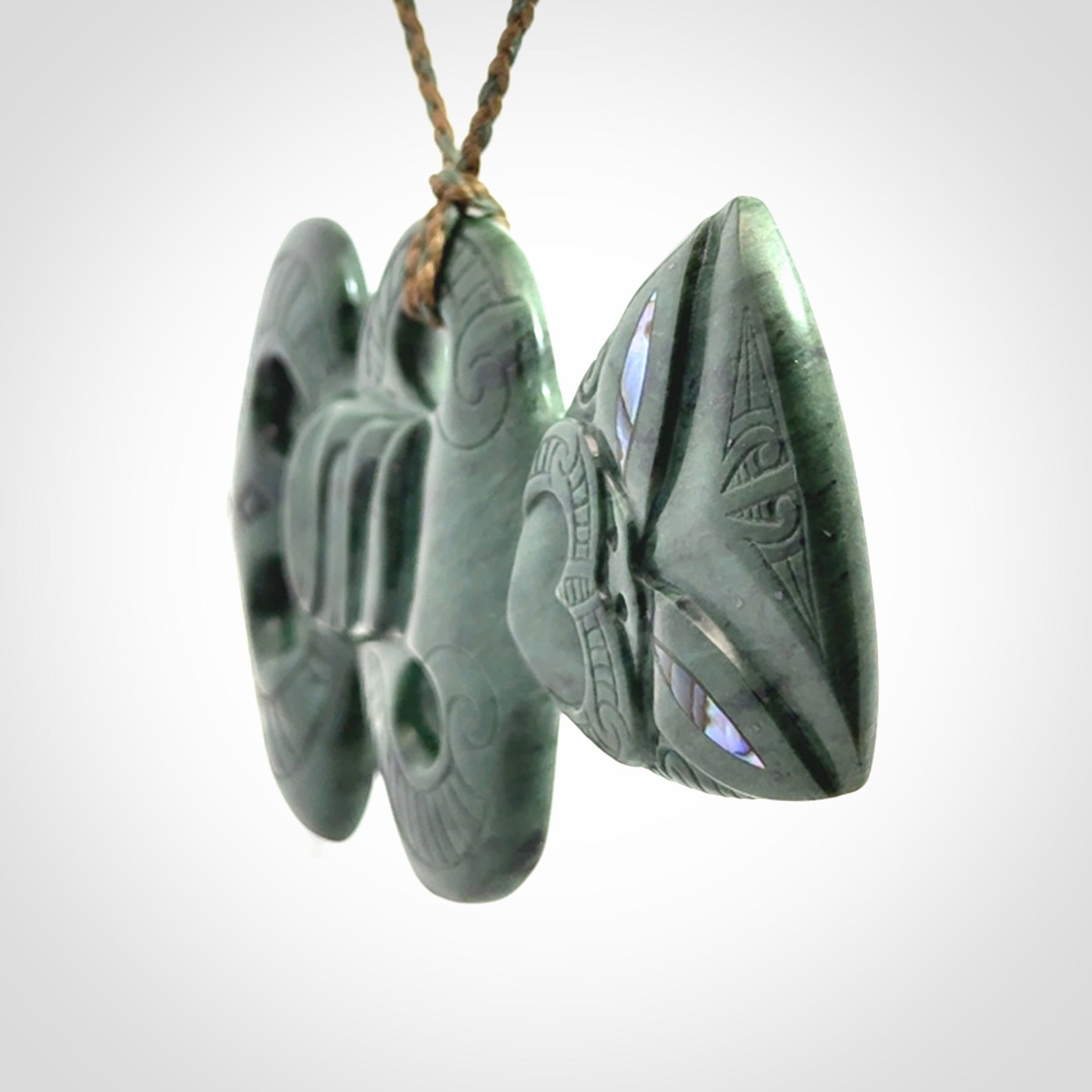 This is a large hand carved New Zealand Jade tiki pendant. It is made from New Zealand Jade and Paua shell.