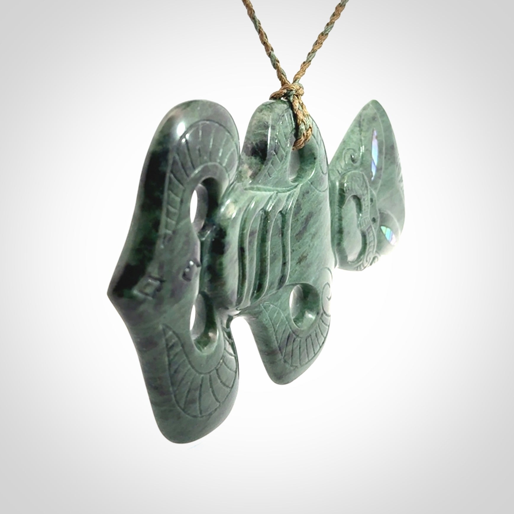 This is a large hand carved New Zealand Jade tiki pendant. It is made from New Zealand Jade and Paua shell.