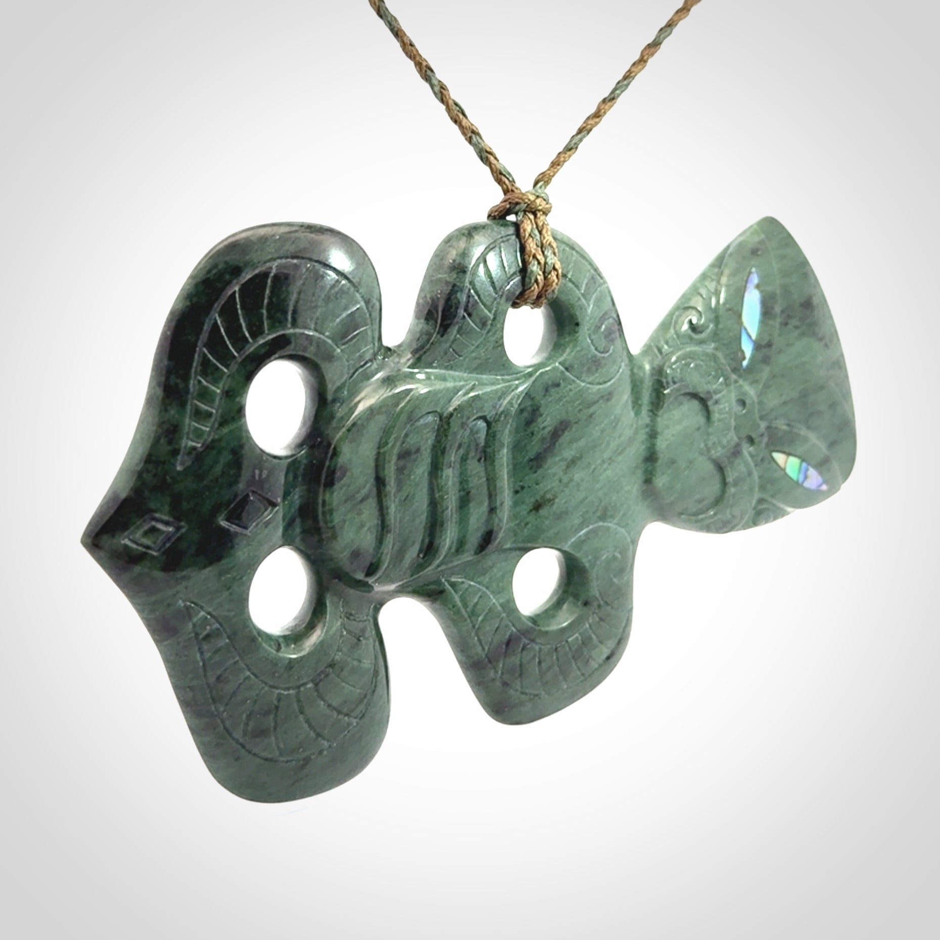 This is a large hand carved New Zealand Jade tiki pendant. It is made from New Zealand Jade and Paua shell.