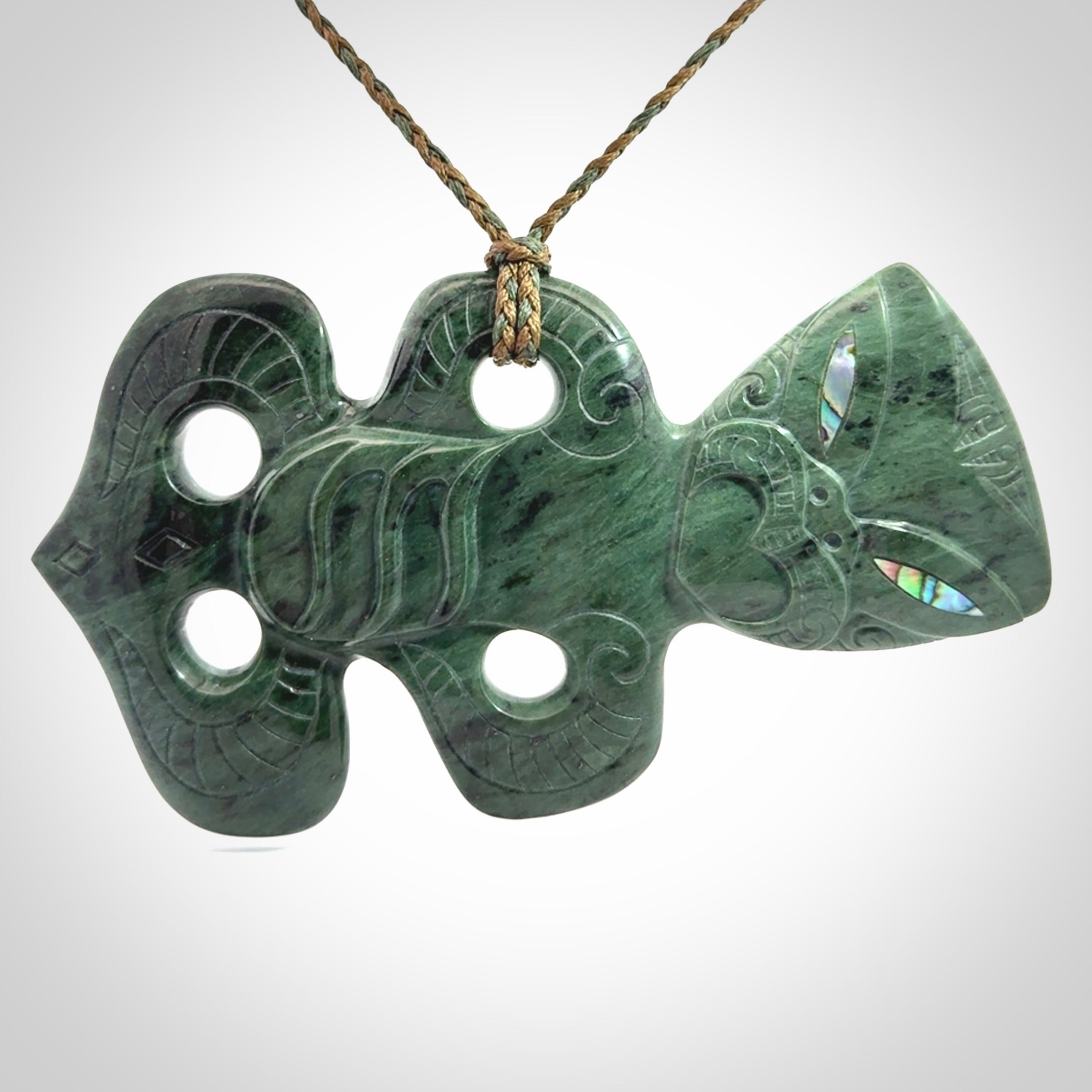 This is a large hand carved New Zealand Jade tiki pendant. It is made from New Zealand Jade and Paua shell.