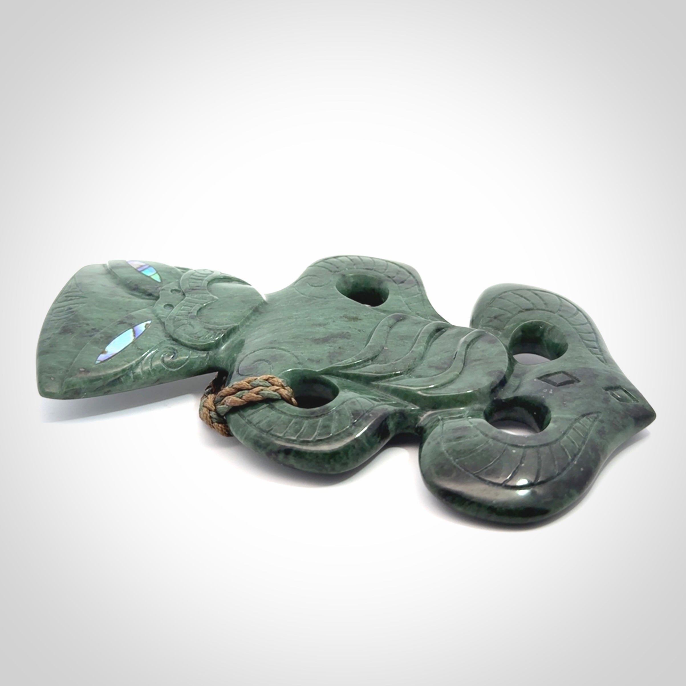 This is a large hand carved New Zealand Jade tiki pendant. It is made from New Zealand Jade and Paua shell.