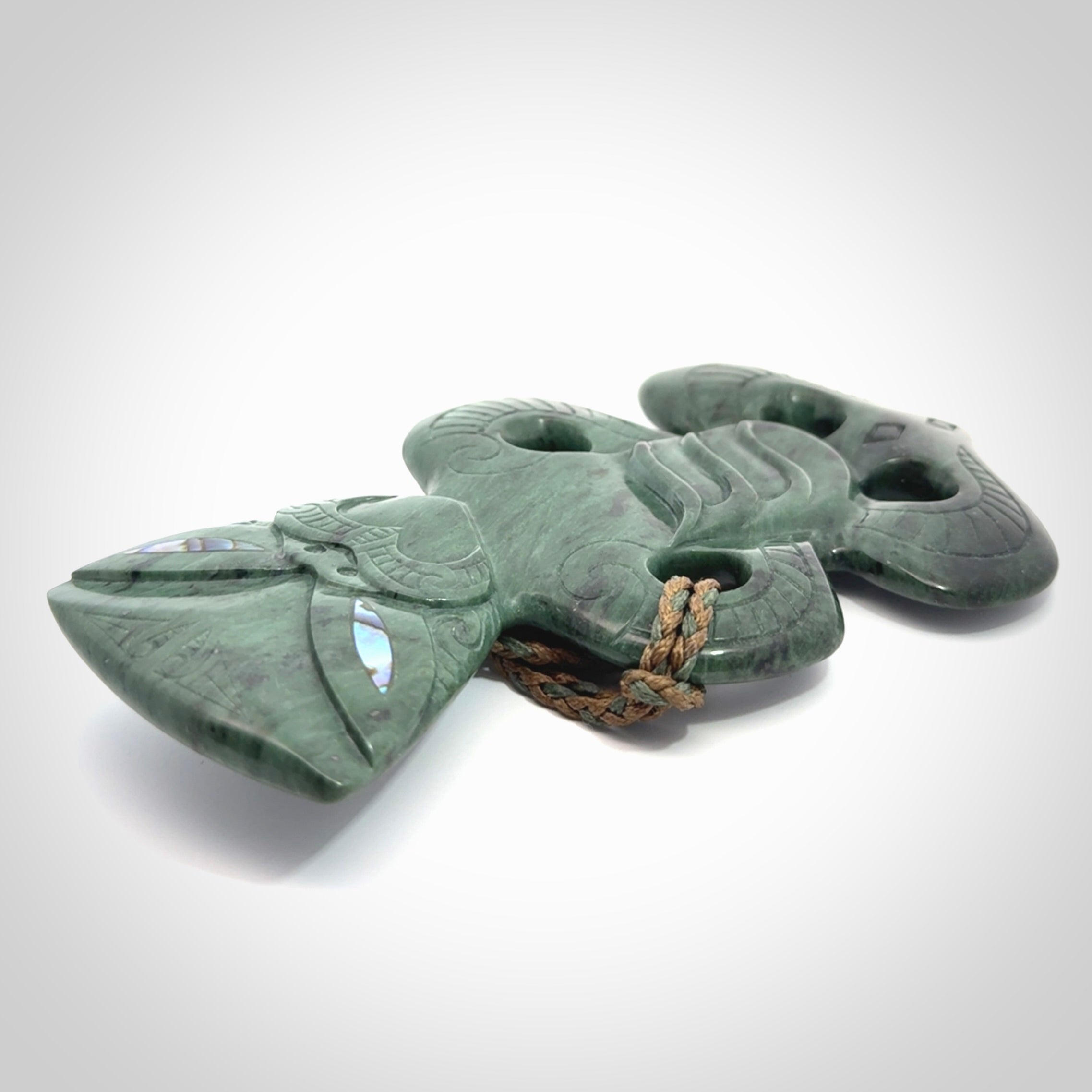 This is a large hand carved New Zealand Jade tiki pendant. It is made from New Zealand Jade and Paua shell.