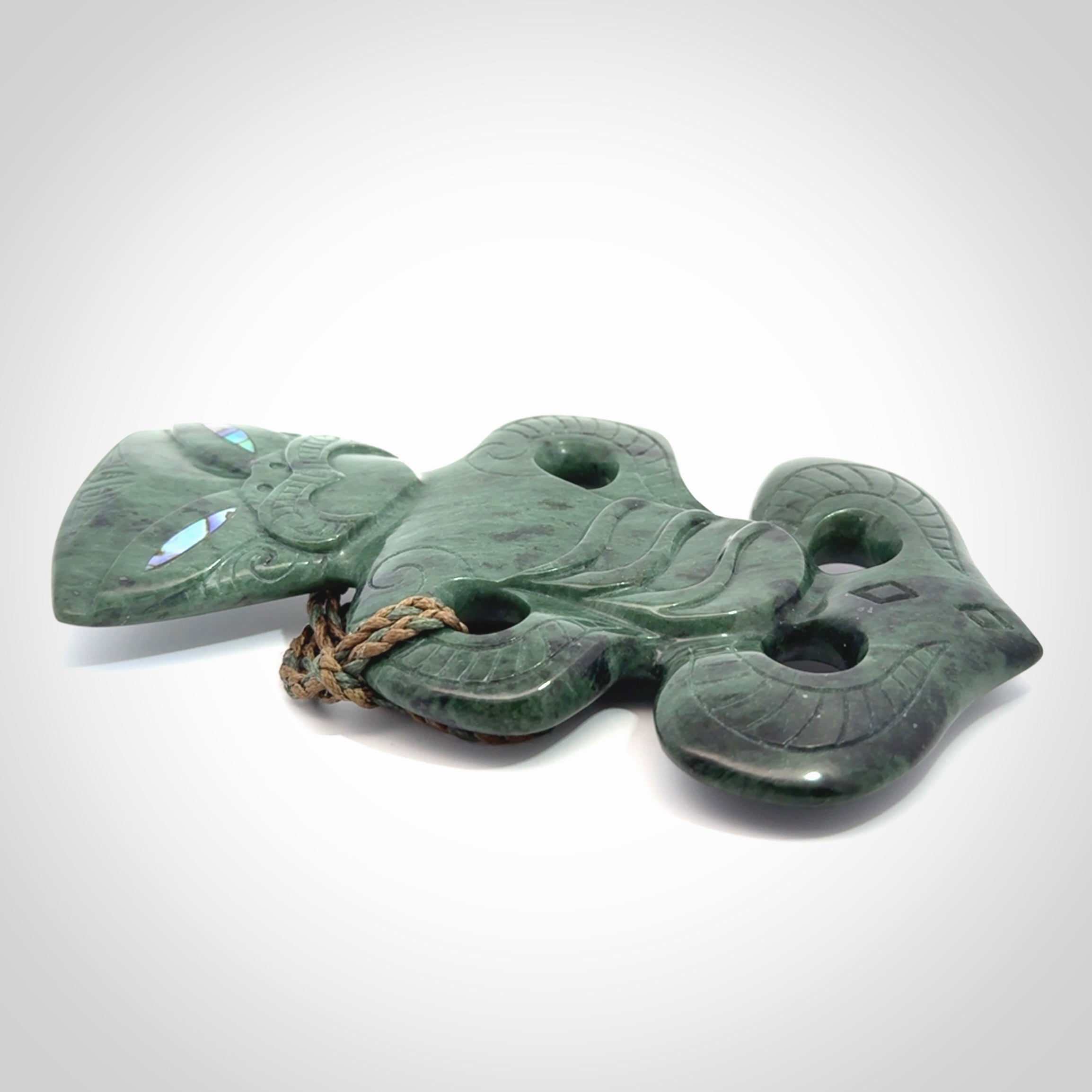 This is a large hand carved New Zealand Jade tiki pendant. It is made from New Zealand Jade and Paua shell.