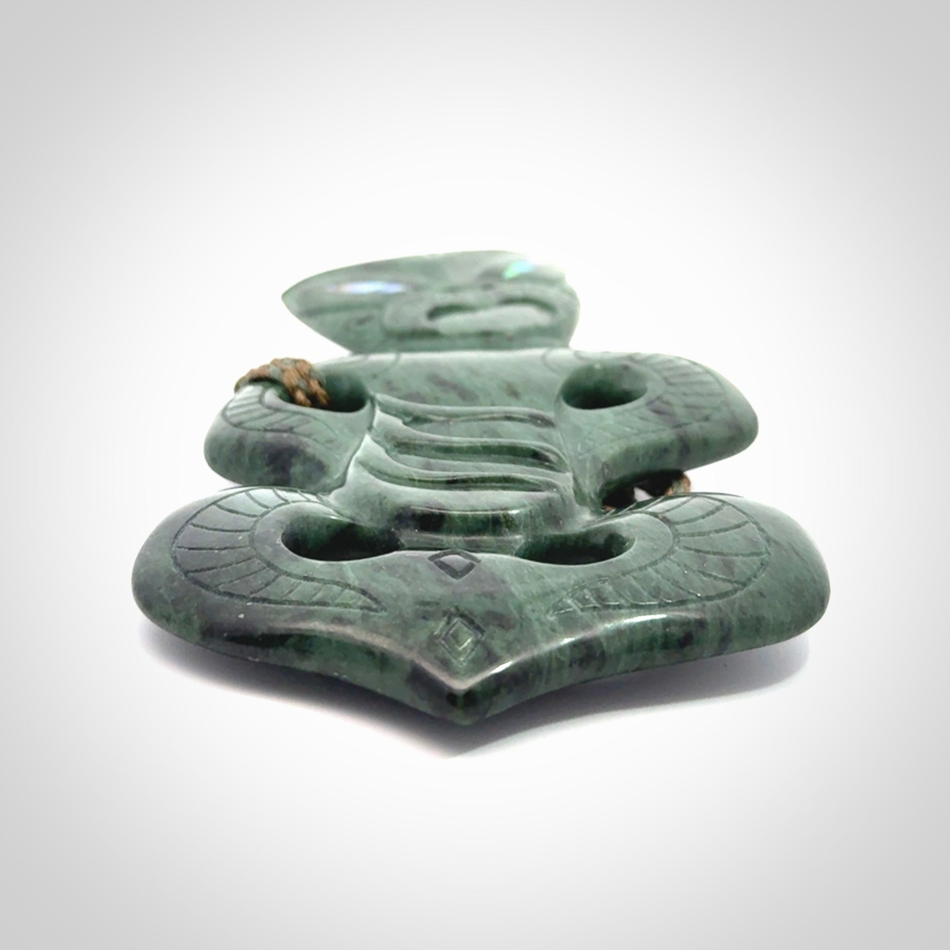 This is a large hand carved New Zealand Jade tiki pendant. It is made from New Zealand Jade and Paua shell.