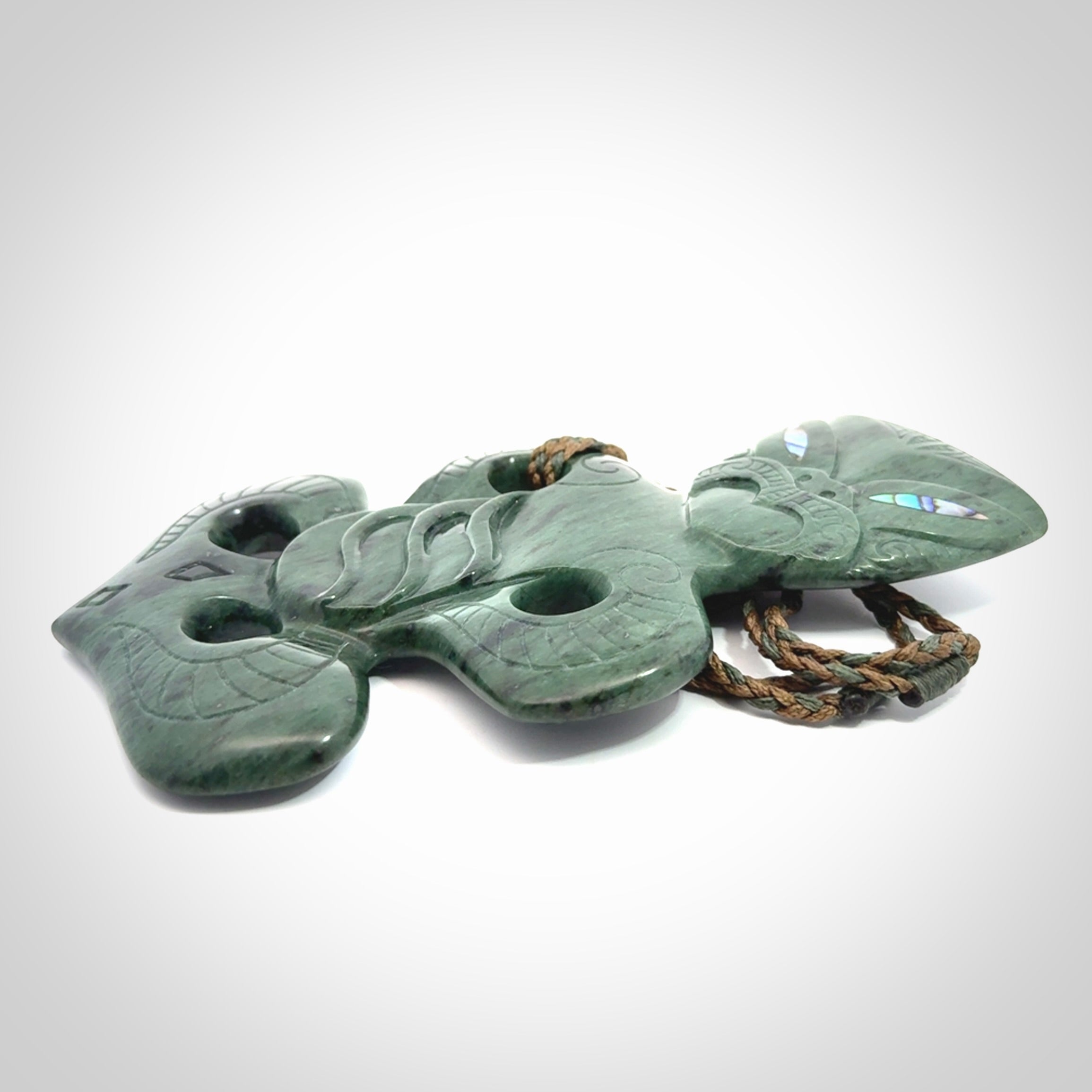 This is a large hand carved New Zealand Jade tiki pendant. It is made from New Zealand Jade and Paua shell.