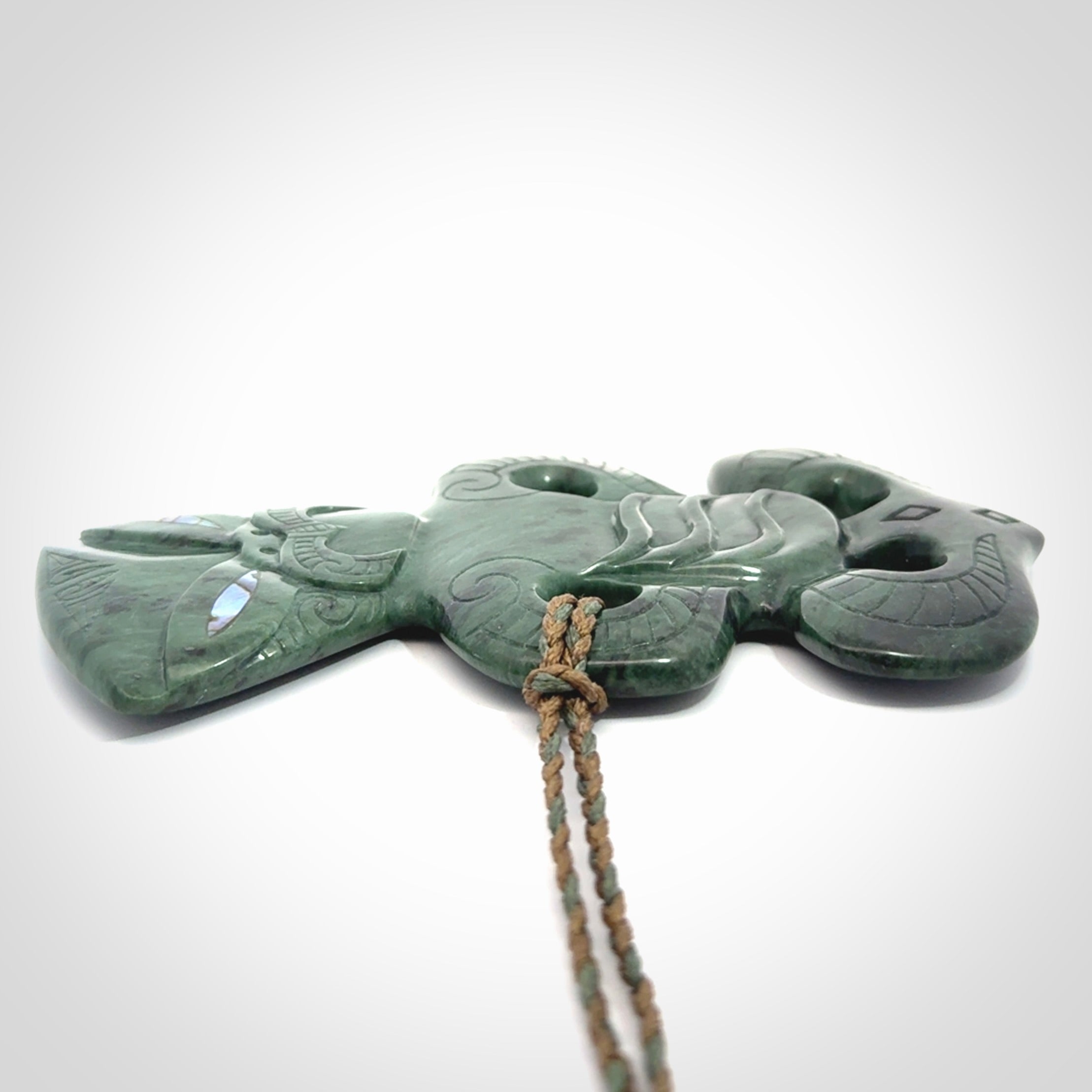 This is a large hand carved New Zealand Jade tiki pendant. It is made from New Zealand Jade and Paua shell.