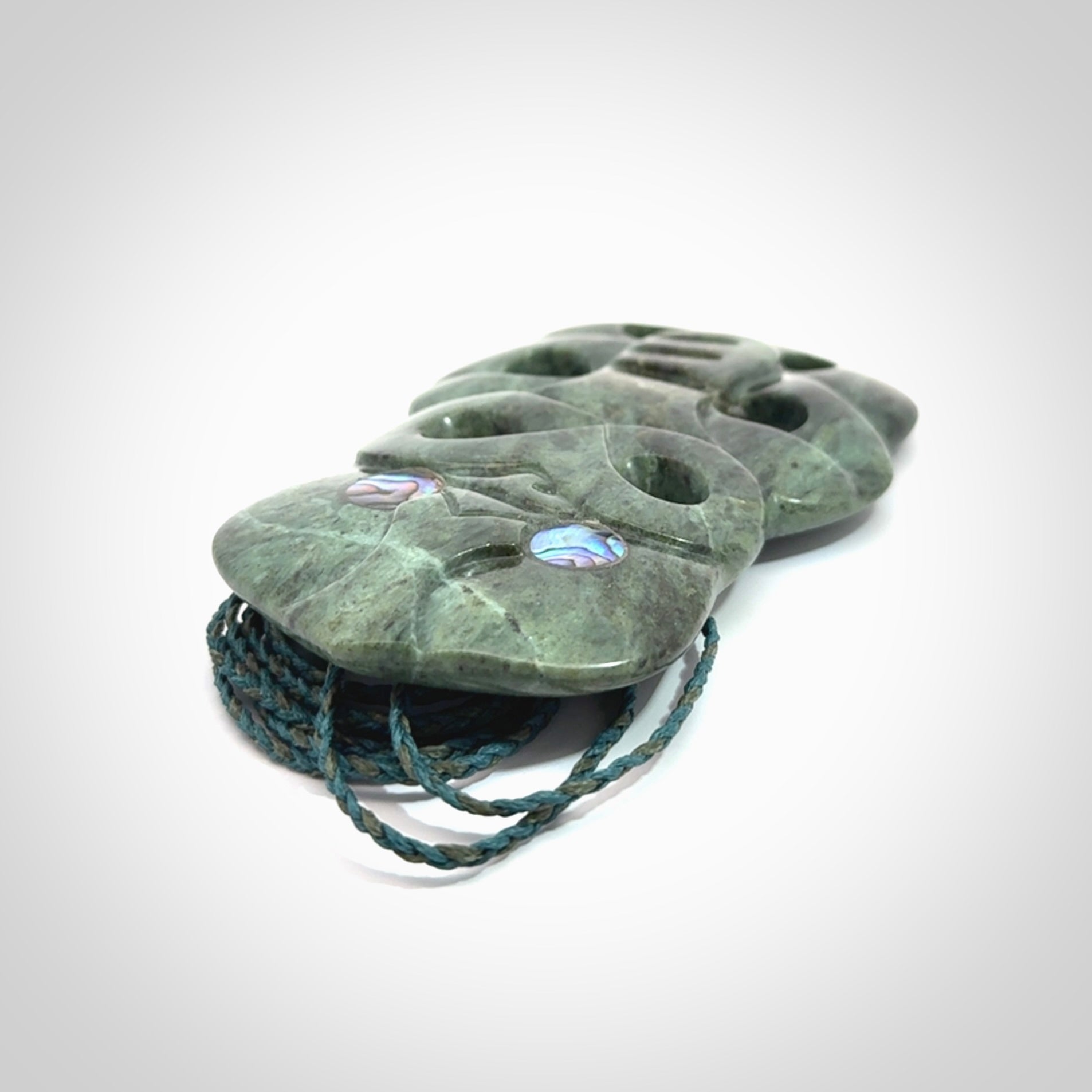 This is a large hand carved New Zealand Jade tiki pendant. It is made from New Zealand Jade and Paua shell.