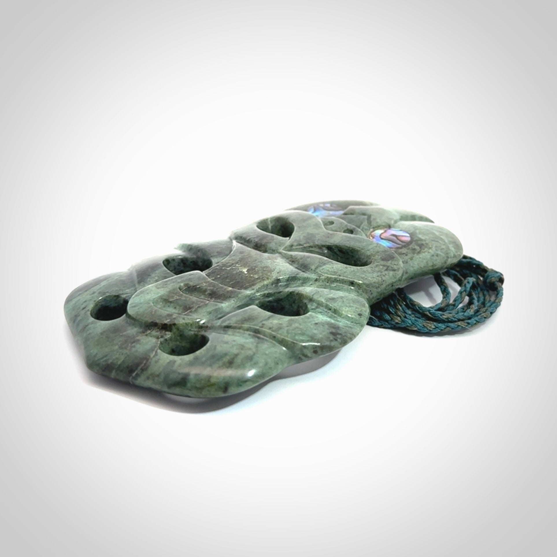 This is a large hand carved New Zealand Jade tiki pendant. It is made from New Zealand Jade and Paua shell.