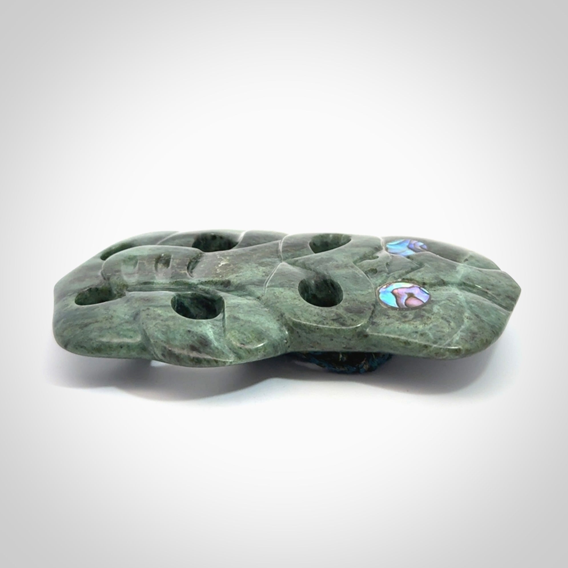 This is a large hand carved New Zealand Jade tiki pendant. It is made from New Zealand Jade and Paua shell.