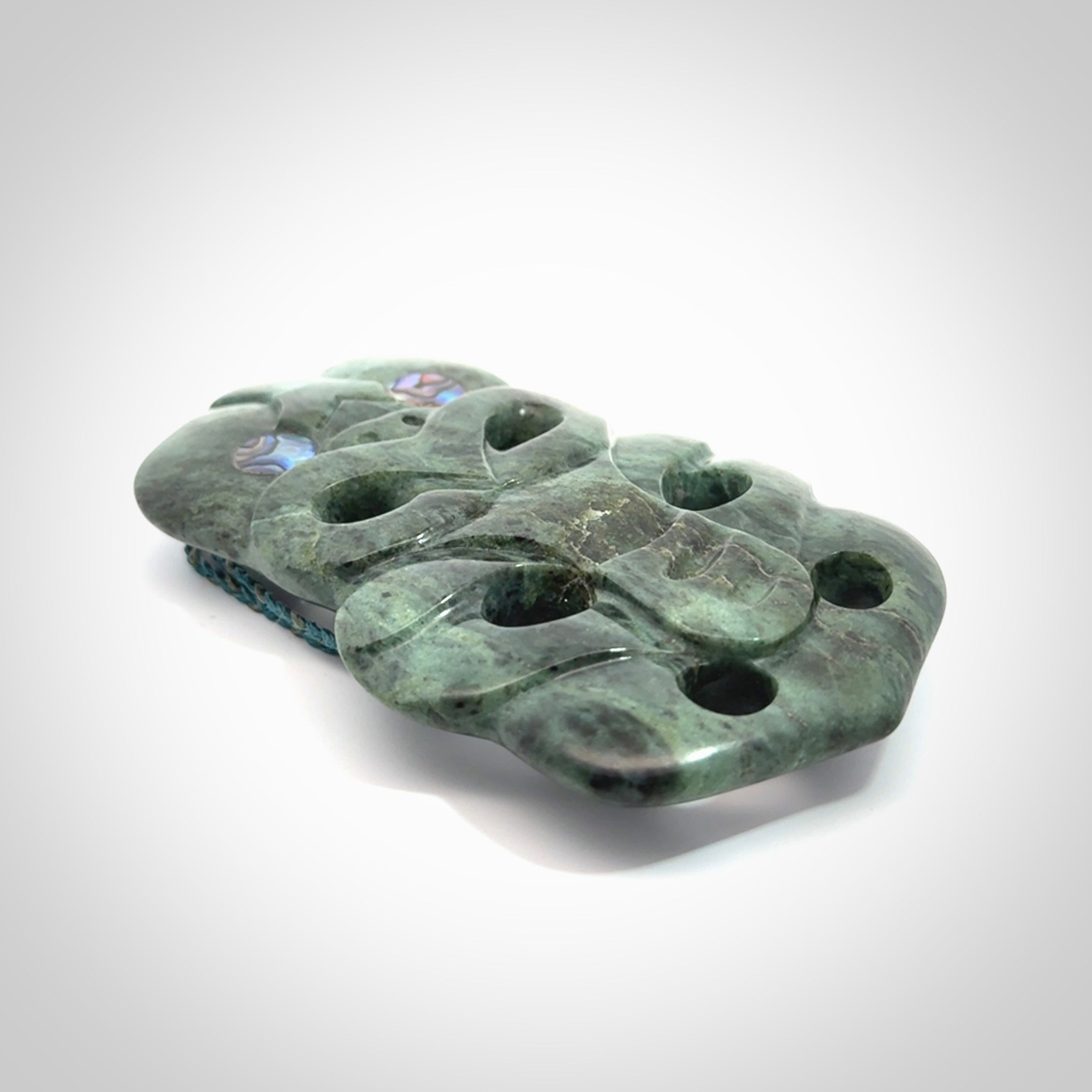 This is a large hand carved New Zealand Jade tiki pendant. It is made from New Zealand Jade and Paua shell.