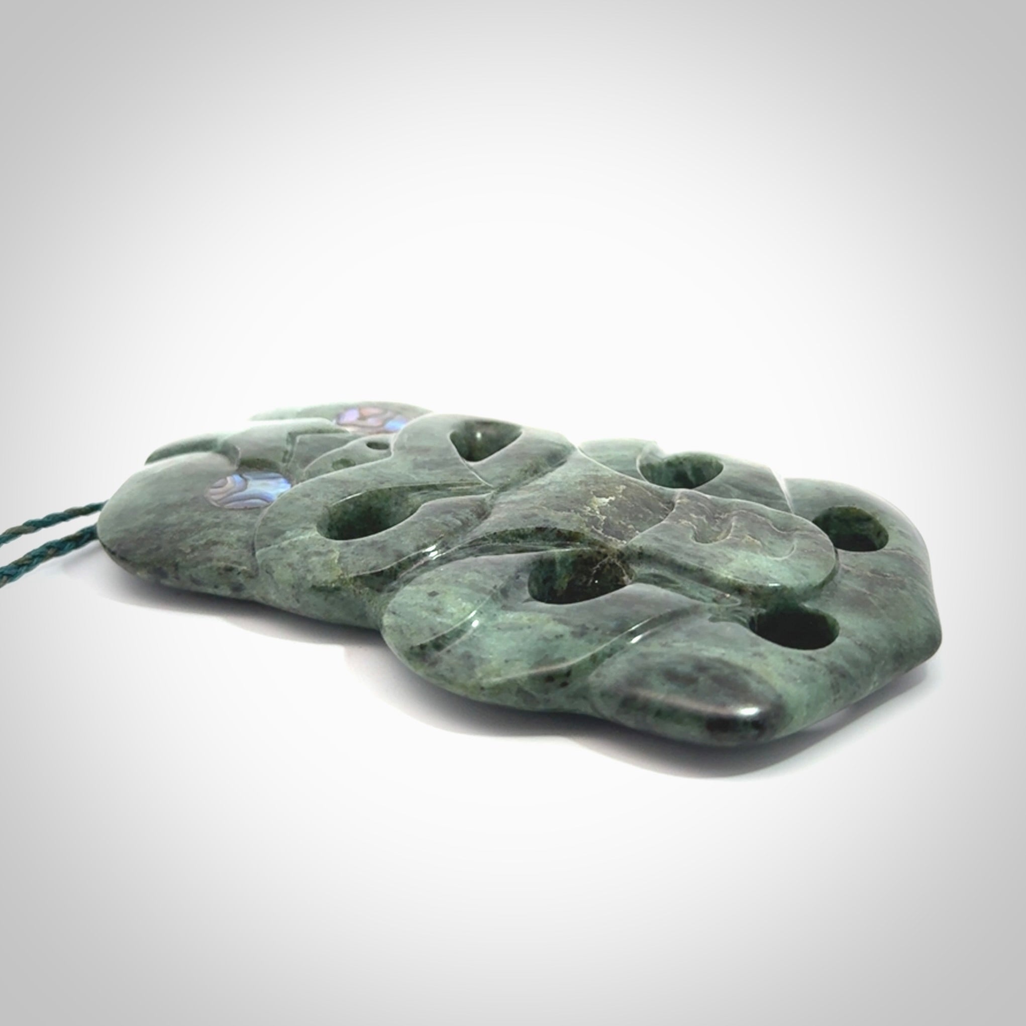 This is a large hand carved New Zealand Jade tiki pendant. It is made from New Zealand Jade and Paua shell.
