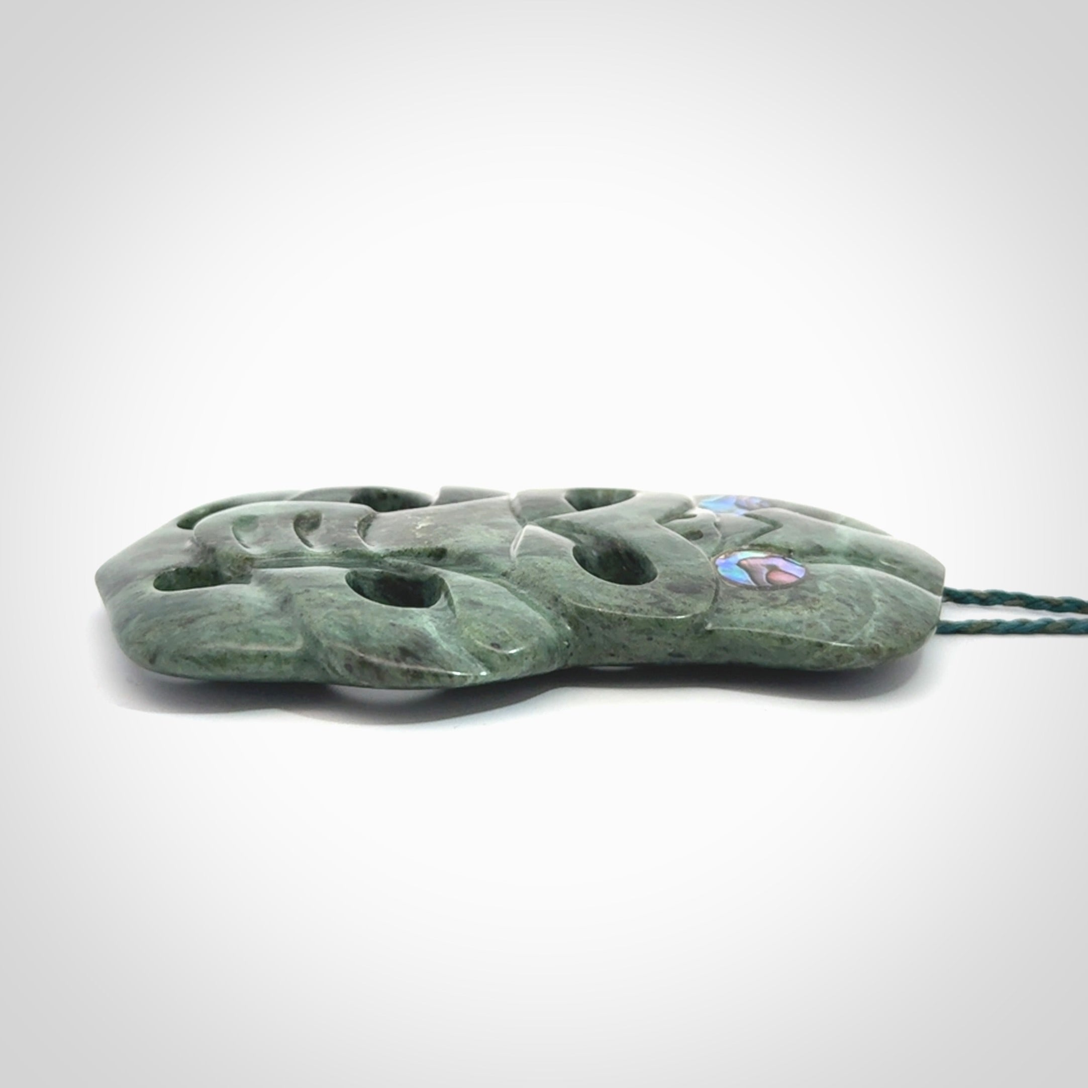 This is a large hand carved New Zealand Jade tiki pendant. It is made from New Zealand Jade and Paua shell.