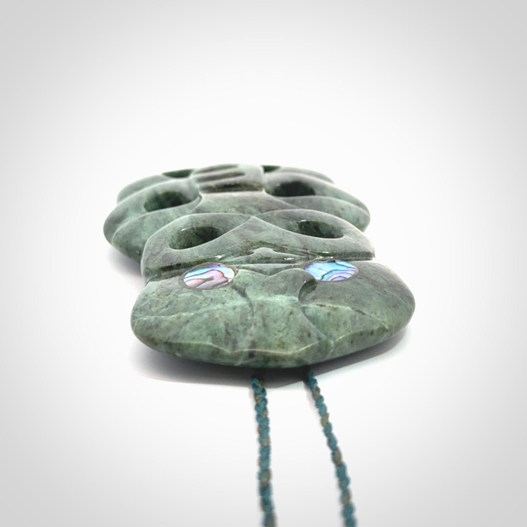 This is a large hand carved New Zealand Jade tiki pendant. It is made from New Zealand Jade and Paua shell.