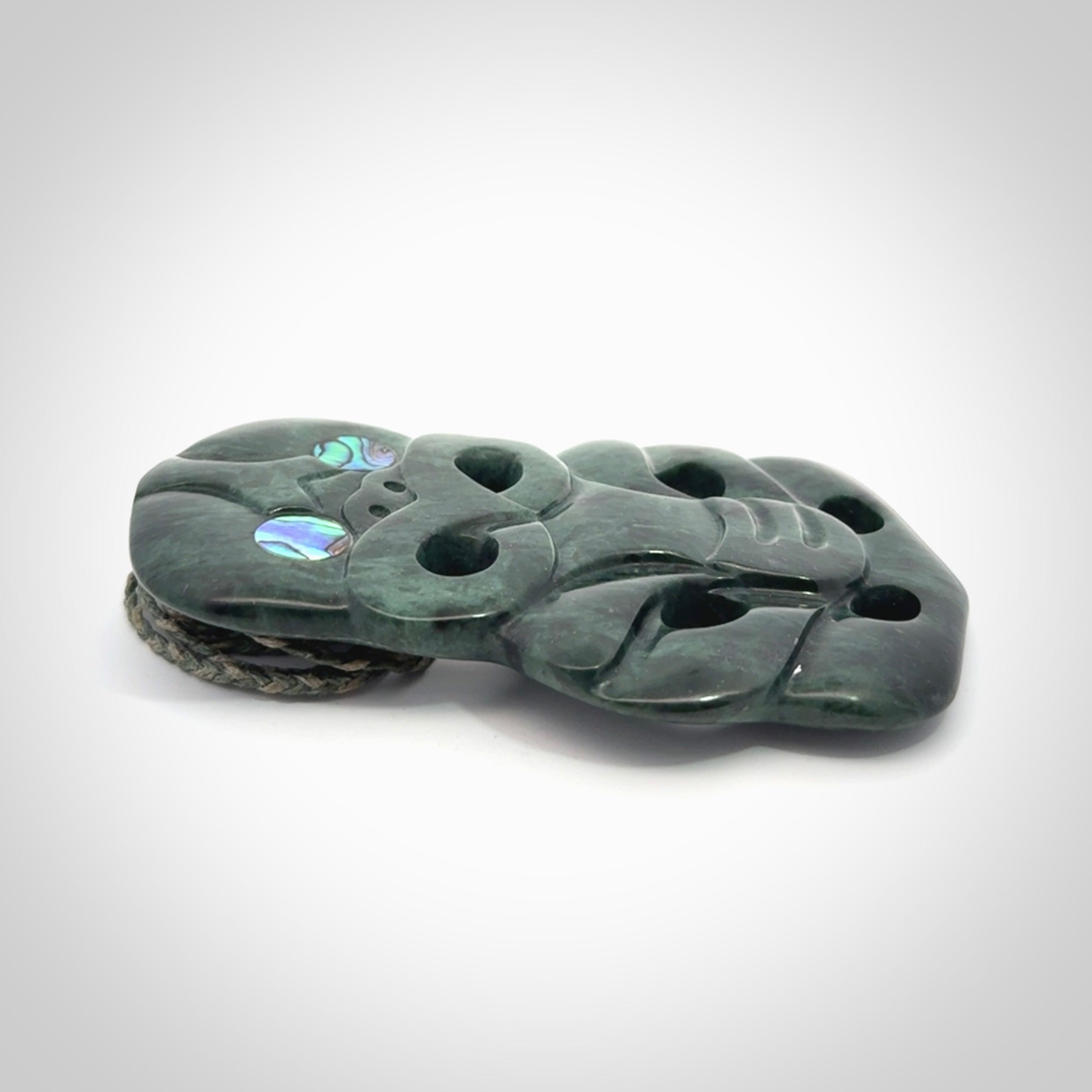 This is a large hand carved New Zealand Jade tiki pendant. It is made from New Zealand Jade and Paua shell.
