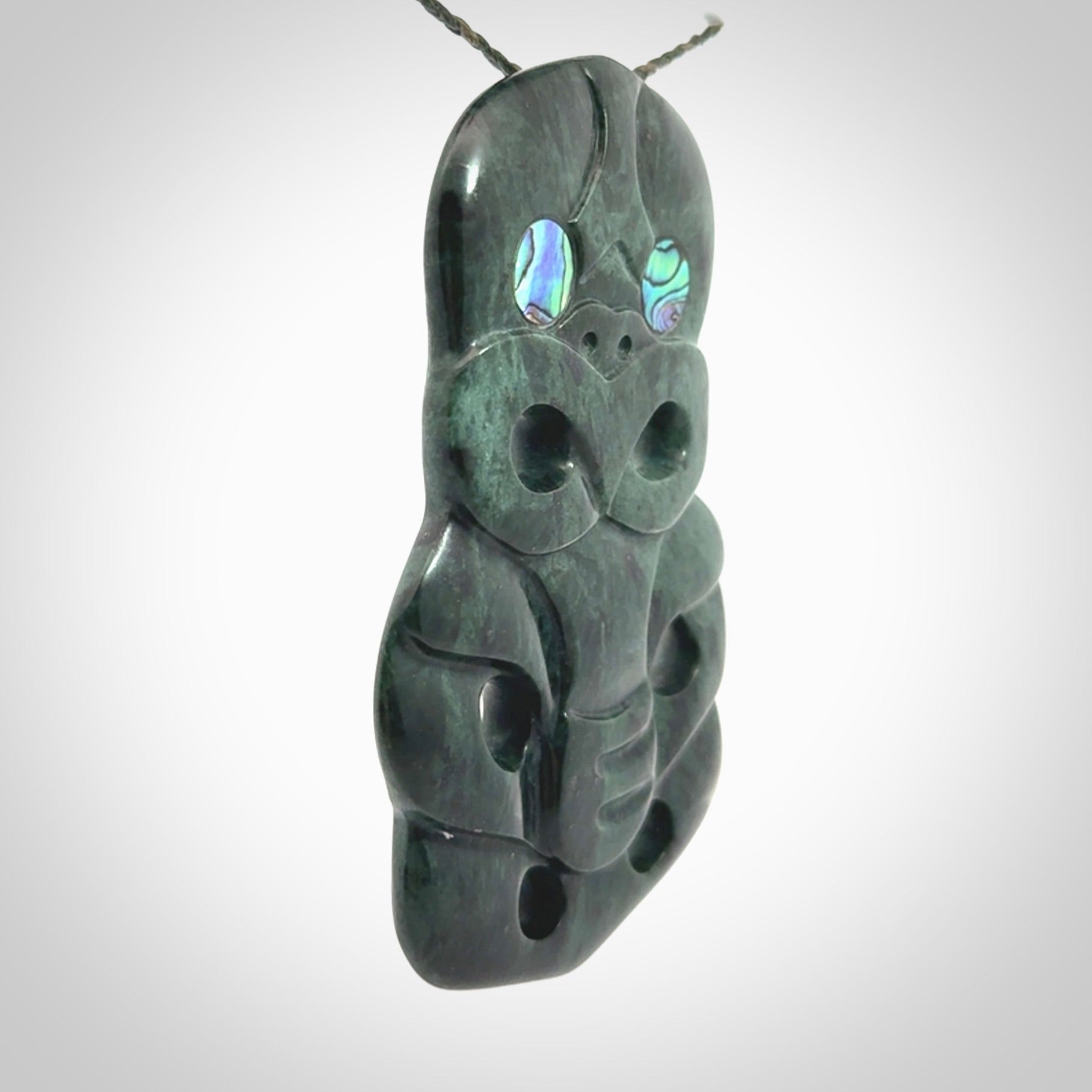This is a large hand carved New Zealand Jade tiki pendant. It is made from New Zealand Jade and Paua shell.