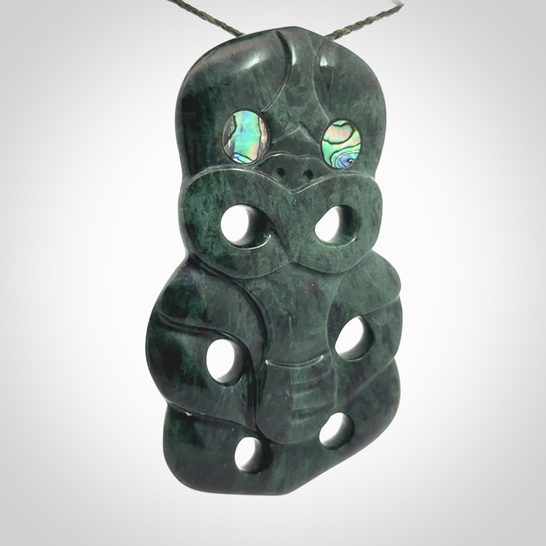This is a large hand carved New Zealand Jade tiki pendant. It is made from New Zealand Jade and Paua shell.