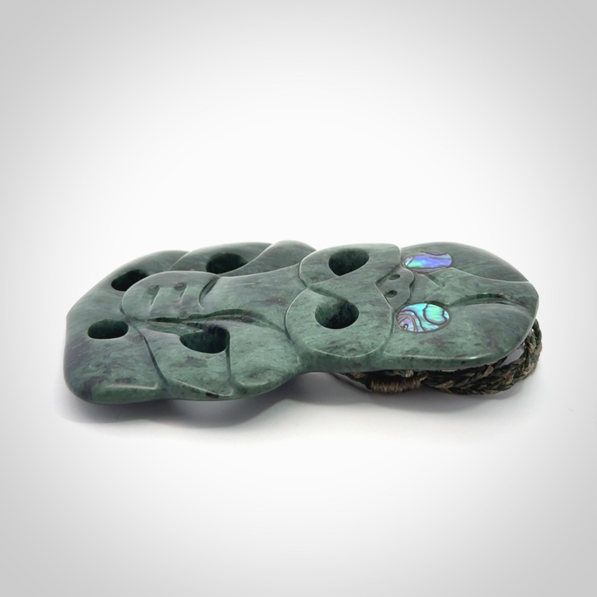 This is a large hand carved New Zealand Jade tiki pendant. It is made from New Zealand Jade and Paua shell.
