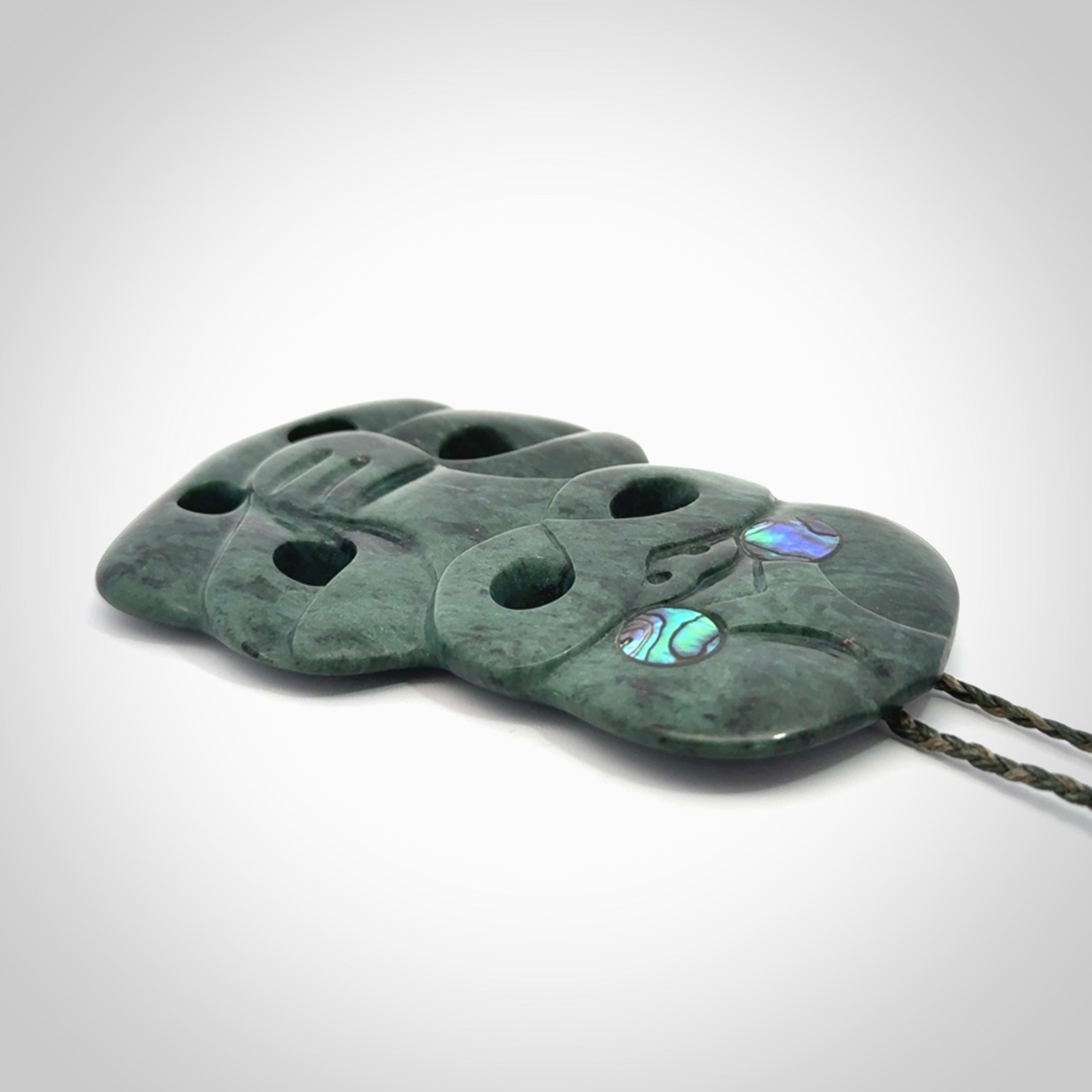 This is a large hand carved New Zealand Jade tiki pendant. It is made from New Zealand Jade and Paua shell.