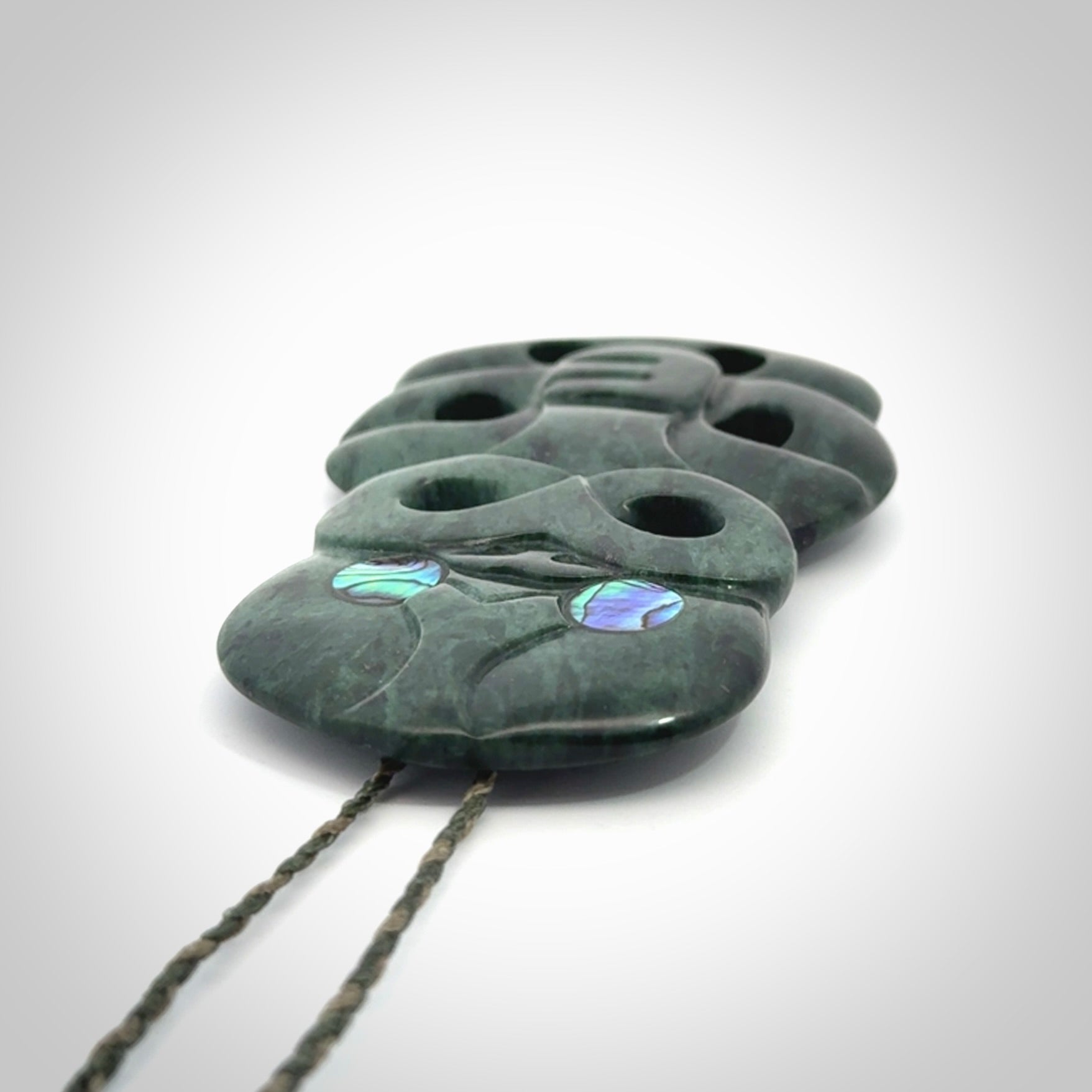 This is a large hand carved New Zealand Jade tiki pendant. It is made from New Zealand Jade and Paua shell.