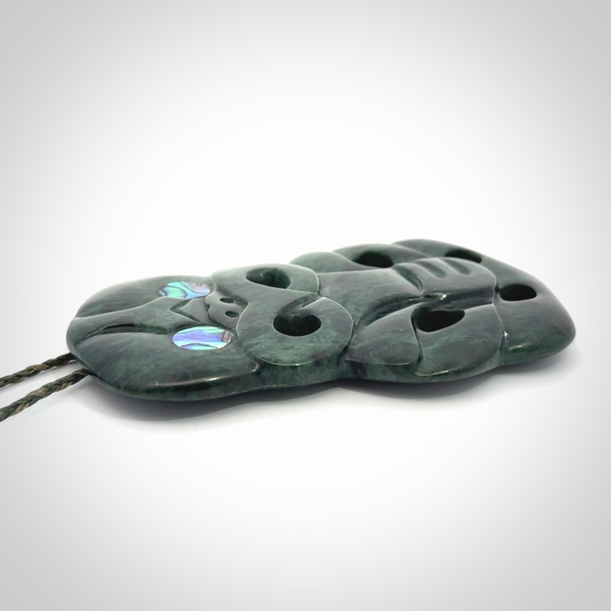 This is a large hand carved New Zealand Jade tiki pendant. It is made from New Zealand Jade and Paua shell.