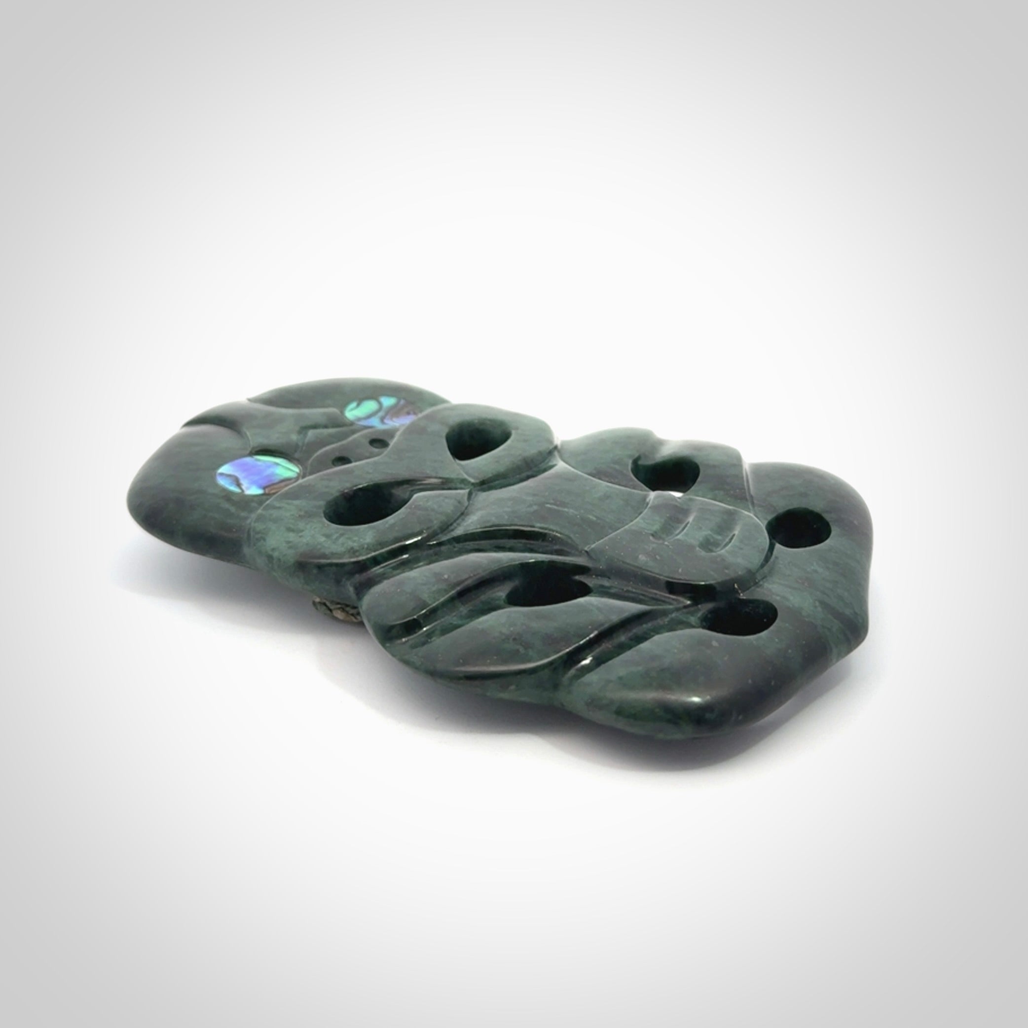 This is a large hand carved New Zealand Jade tiki pendant. It is made from New Zealand Jade and Paua shell.