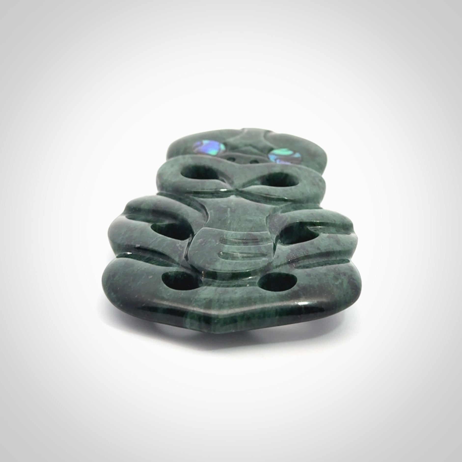 This is a large hand carved New Zealand Jade tiki pendant. It is made from New Zealand Jade and Paua shell.