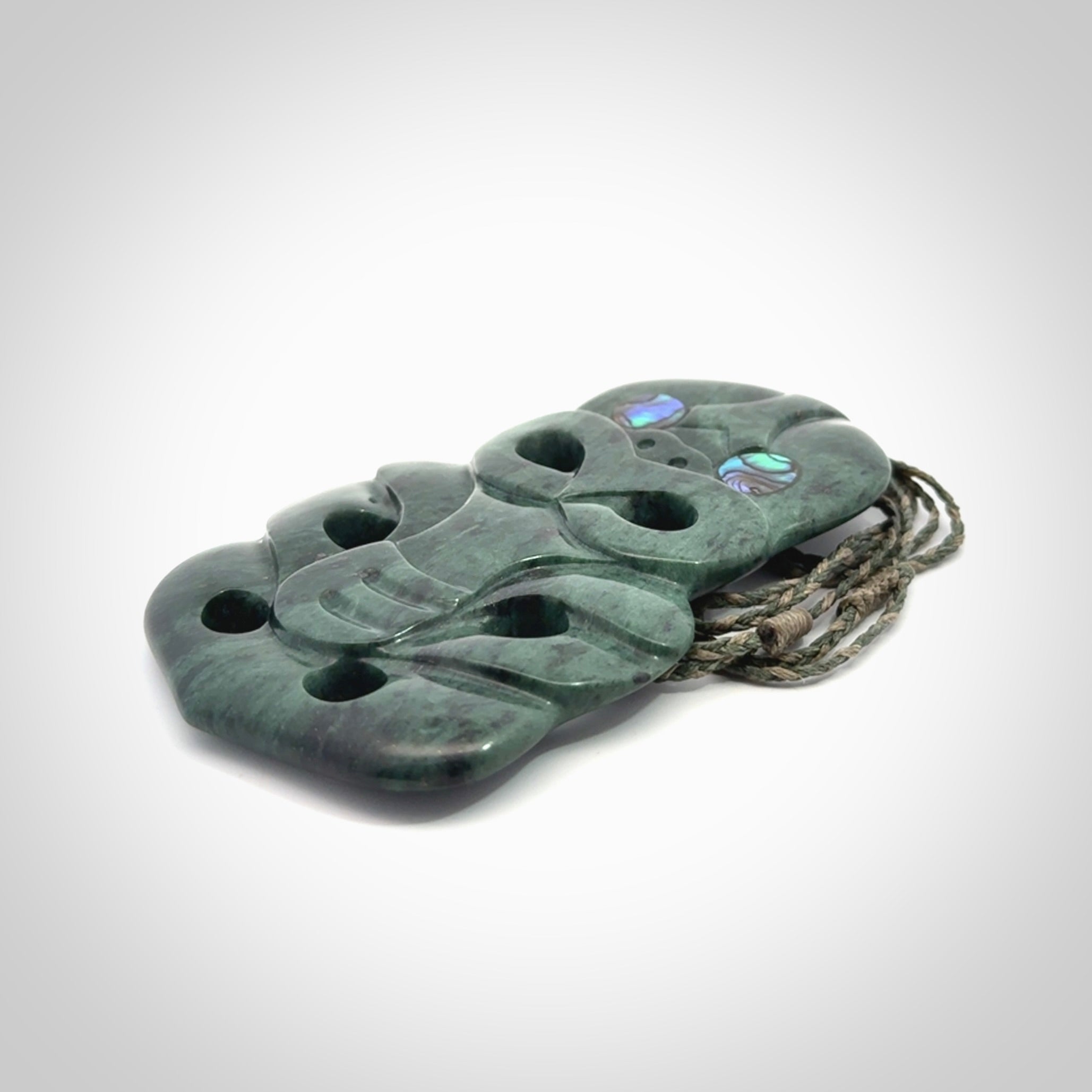 This is a large hand carved New Zealand Jade tiki pendant. It is made from New Zealand Jade and Paua shell.
