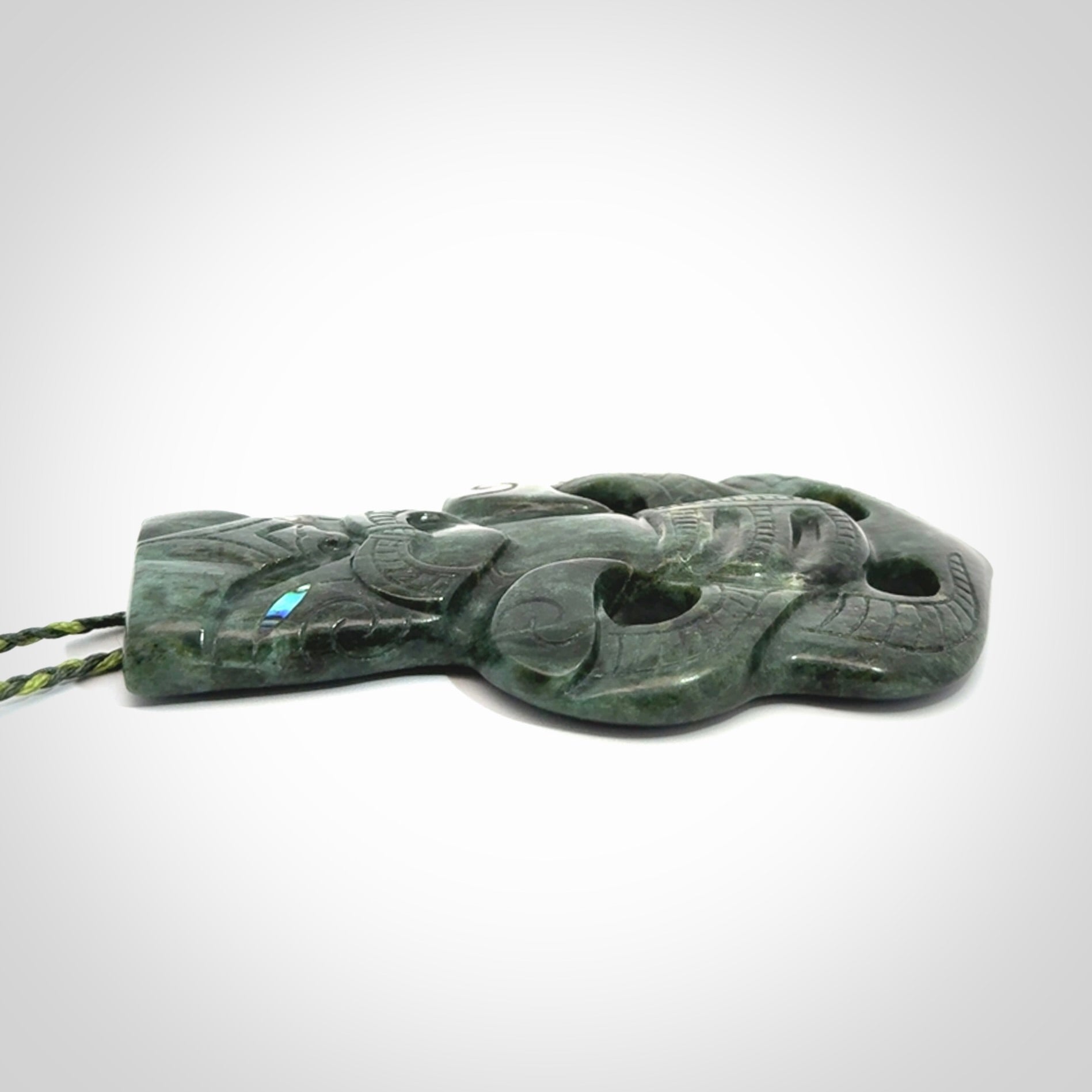 This is a large hand carved New Zealand Jade tiki pendant. It is made from New Zealand Jade and Paua shell.