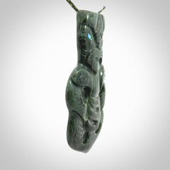 This is a large hand carved New Zealand Jade tiki pendant. It is made from New Zealand Jade and Paua shell.