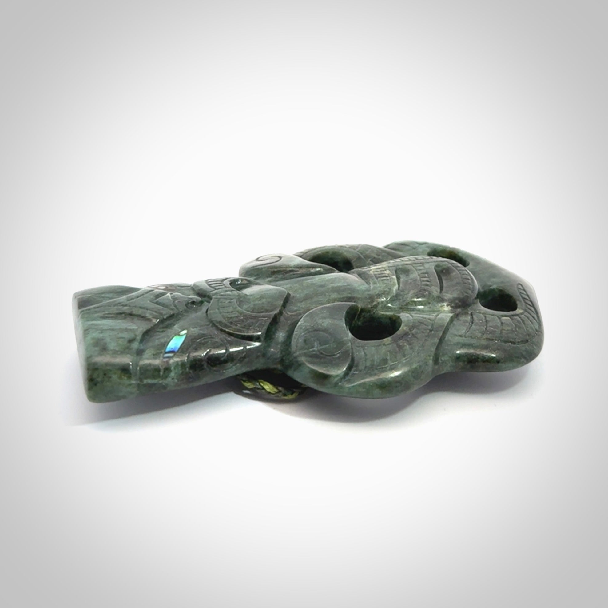This is a large hand carved New Zealand Jade tiki pendant. It is made from New Zealand Jade and Paua shell.