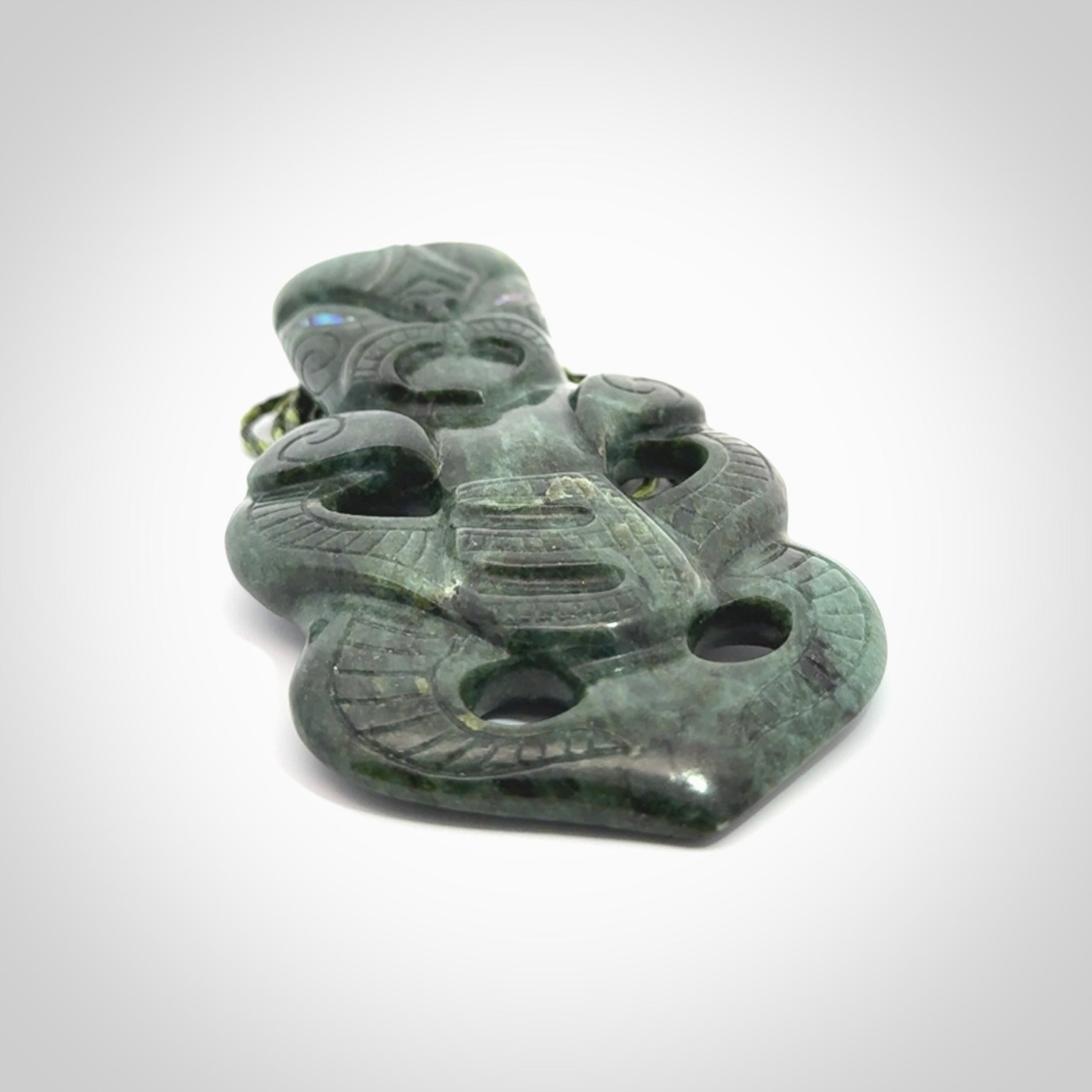 This is a large hand carved New Zealand Jade tiki pendant. It is made from New Zealand Jade and Paua shell.