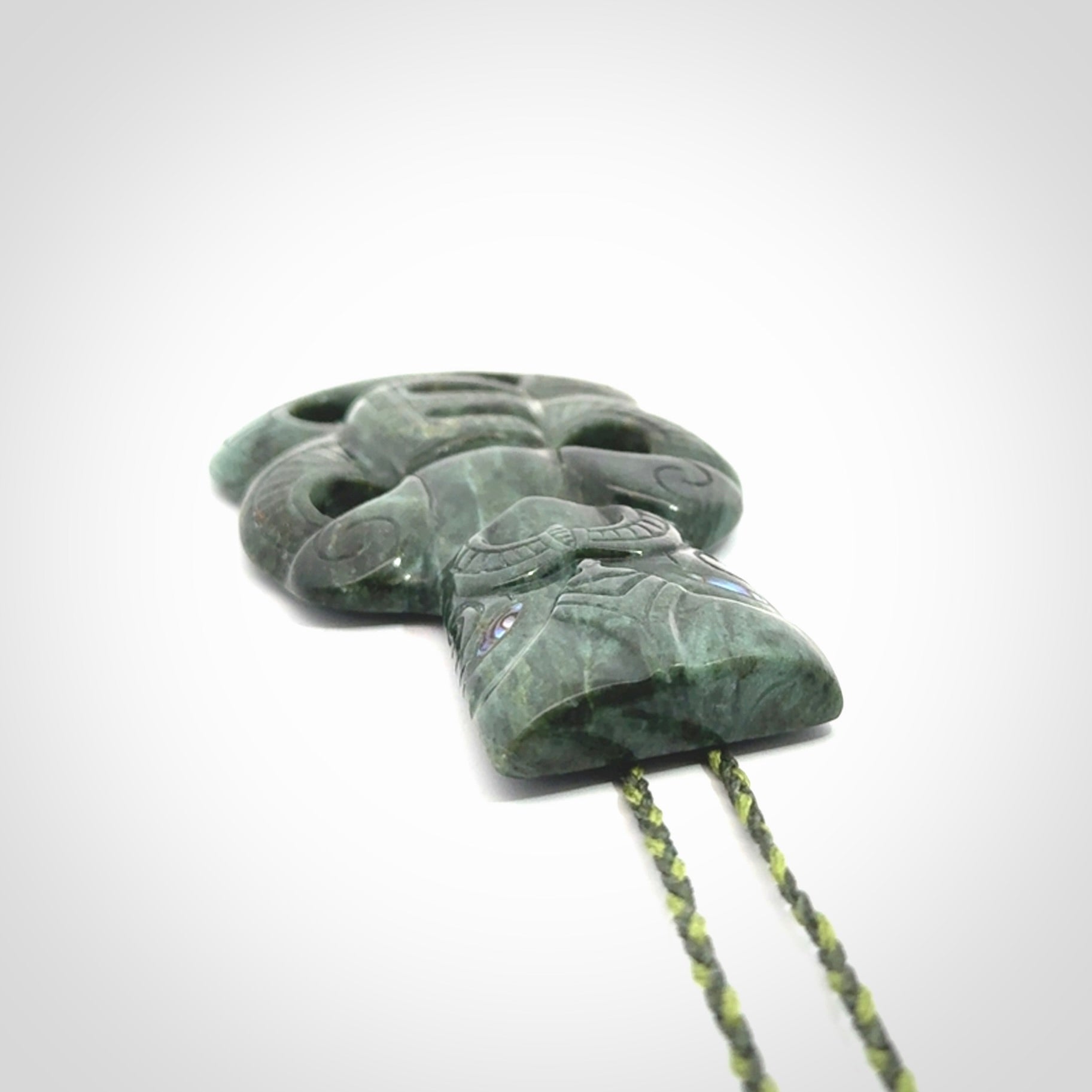 This is a large hand carved New Zealand Jade tiki pendant. It is made from New Zealand Jade and Paua shell.