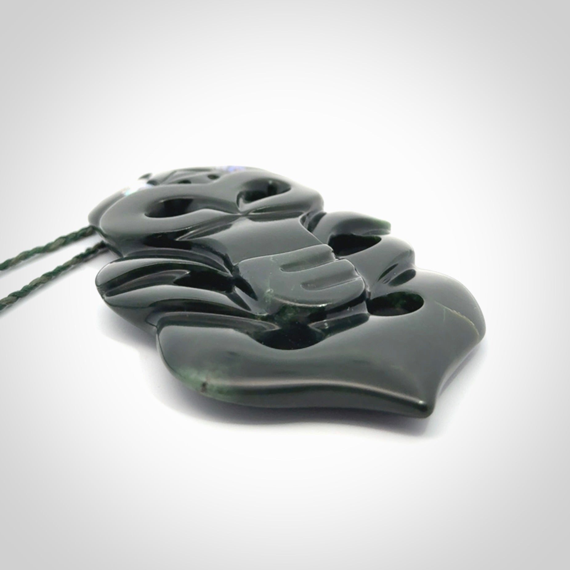 This is a large hand carved New Zealand Jade tiki pendant. It is made from New Zealand Jade and Paua shell.