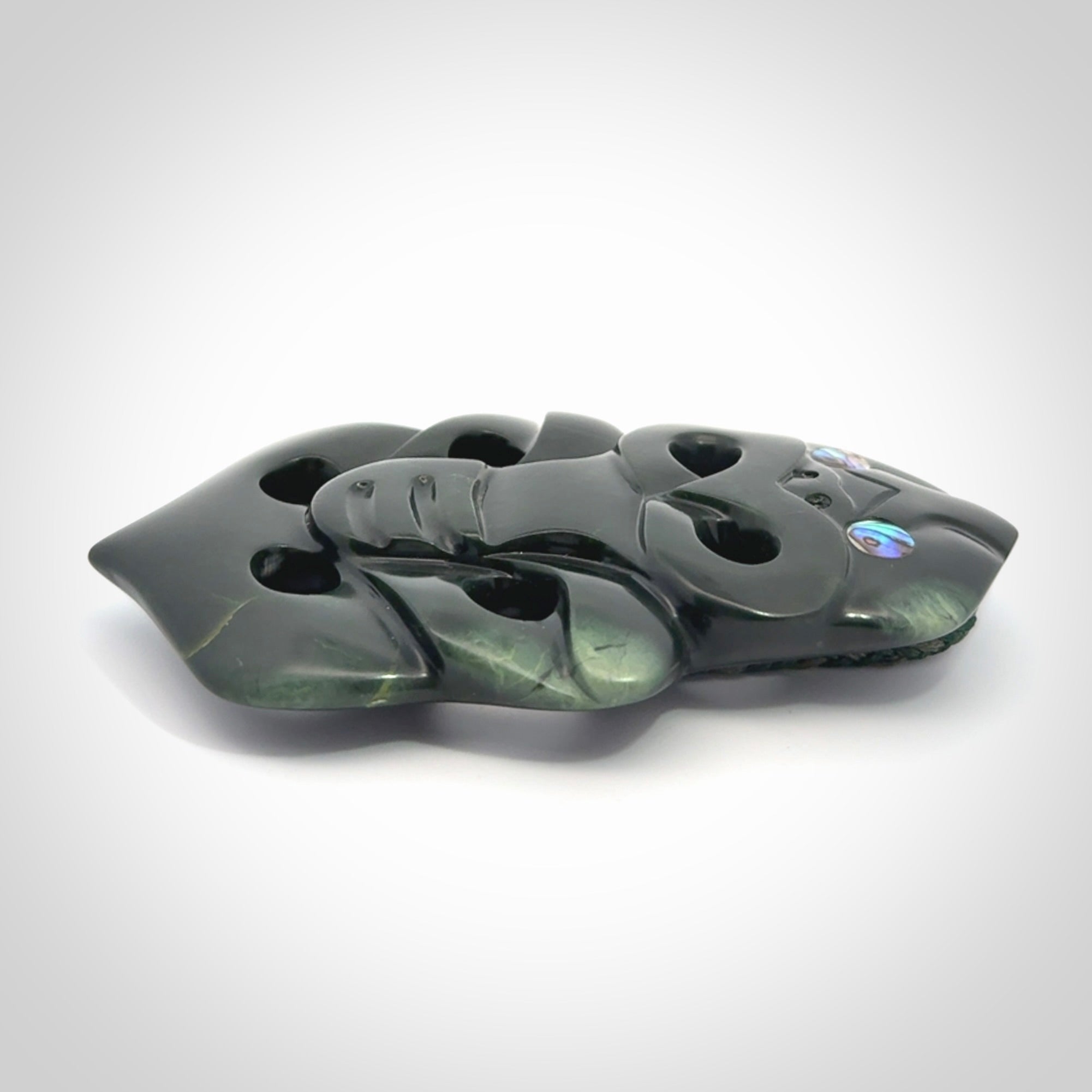 This is a large hand carved New Zealand Jade tiki pendant. It is made from New Zealand Jade and Paua shell.